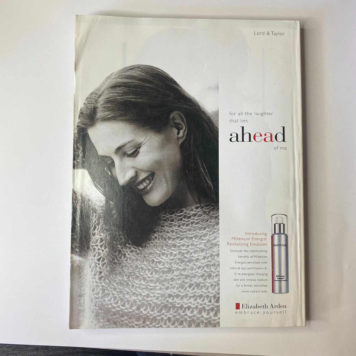 Vogue Magazine October 1999 Winona Ryder Cover presenting a vintage advertisement for Elizabeth Arden skincare, featuring a woman smiling warmly, promoting energy and youthful appearance.