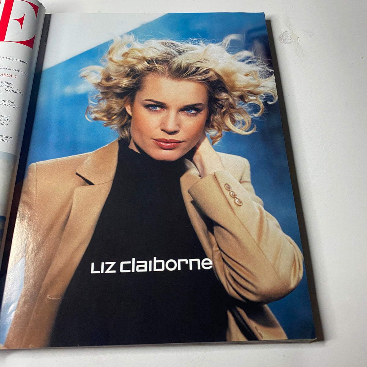 Vogue Magazine August 2001 featuring Amber Valletta on the cover with a stylish Liz Claiborne advertisement showcasing a model with curly hair dressed in a beige blazer against a blurred urban background.