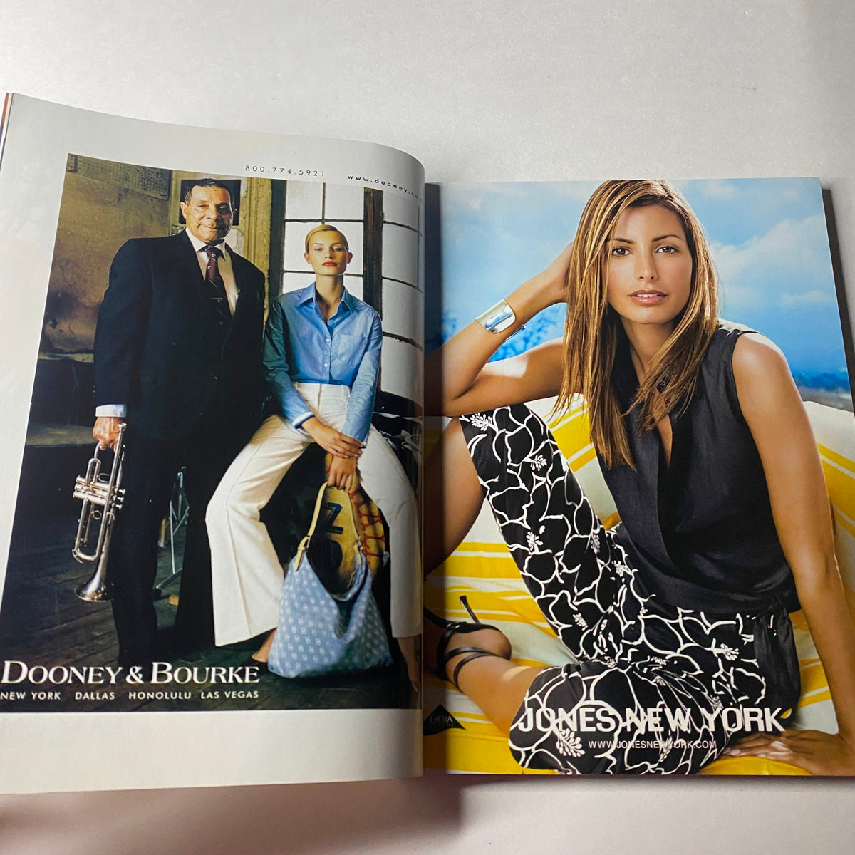 Vogue Magazine June 2002 page featuring a Dooney & Bourke advertisement, highlighting stylish accessories with models in a vibrant outdoor setting.