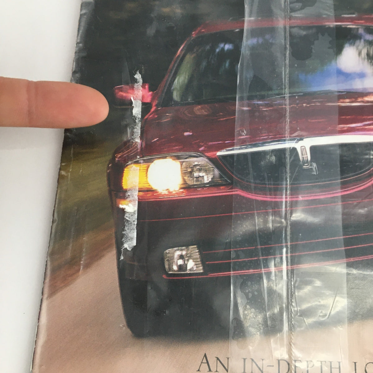 Close-up of Road & Track Magazine 2001 Guide to All New Lincoln LS showing details of the luxury-sport sedan and indicating the magazine's sealed condition.
