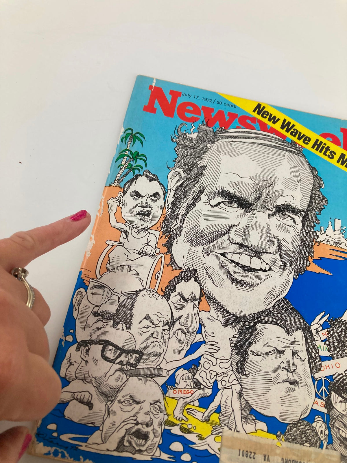 Close-up view of the VTG Newsweek Magazine cover from July 17, 1972, highlighting the detailed caricatures related to 'A New Wave Hits Miami,' with a person pointing at the cover.