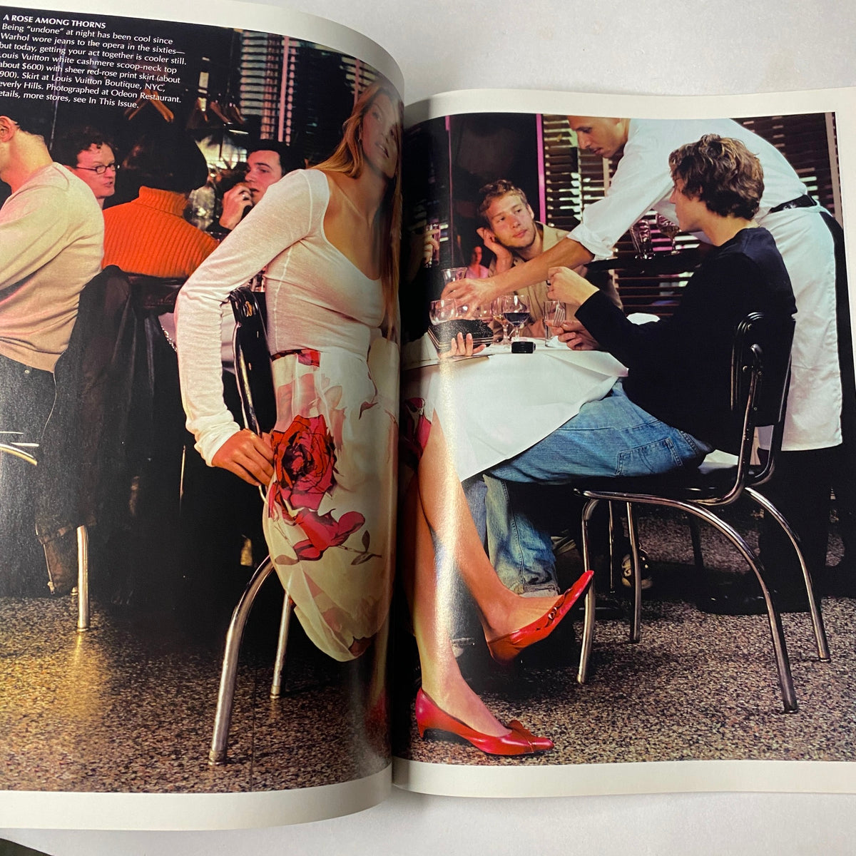Inside spread of Vogue Magazine January 2001 featuring a fashionable dining scene with guests enjoying a meal, highlighting styles from the era.