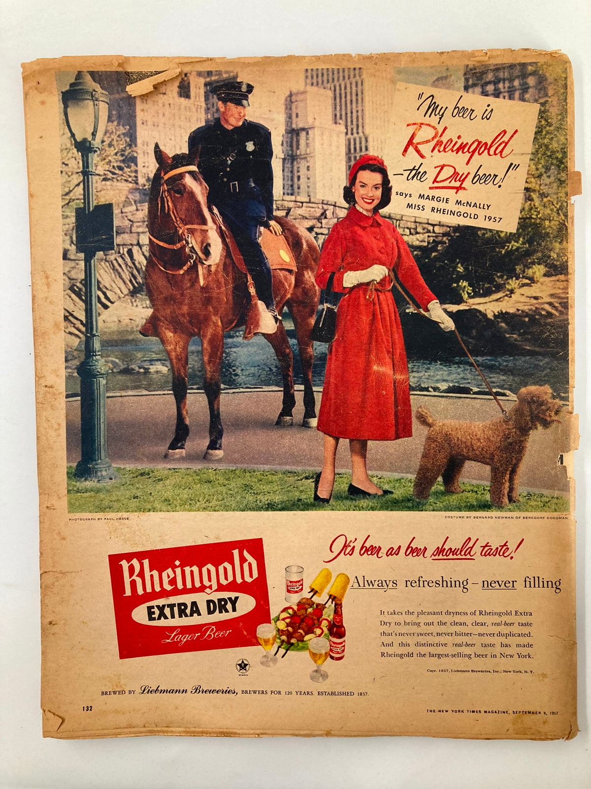 Advertisement page from VTG The New York Times Magazine September 8 1957 featuring the Rheingold Extra Dry beer ad, depicting a woman in a red coat and a police officer.