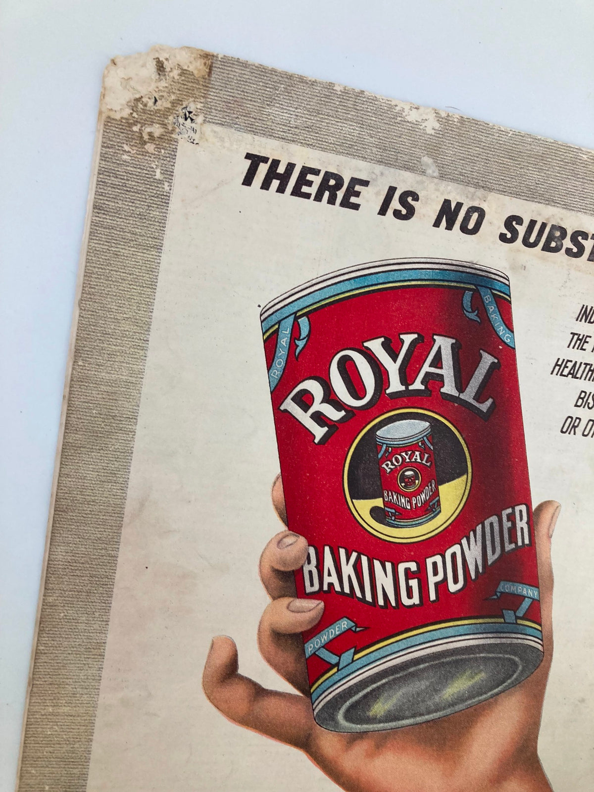Close-up view of a vintage Royal Baking Powder can advertisement, showcasing the hand holding the can with text highlighting its purity and quality. From VTG The Sunday Magazine January 1 1905.