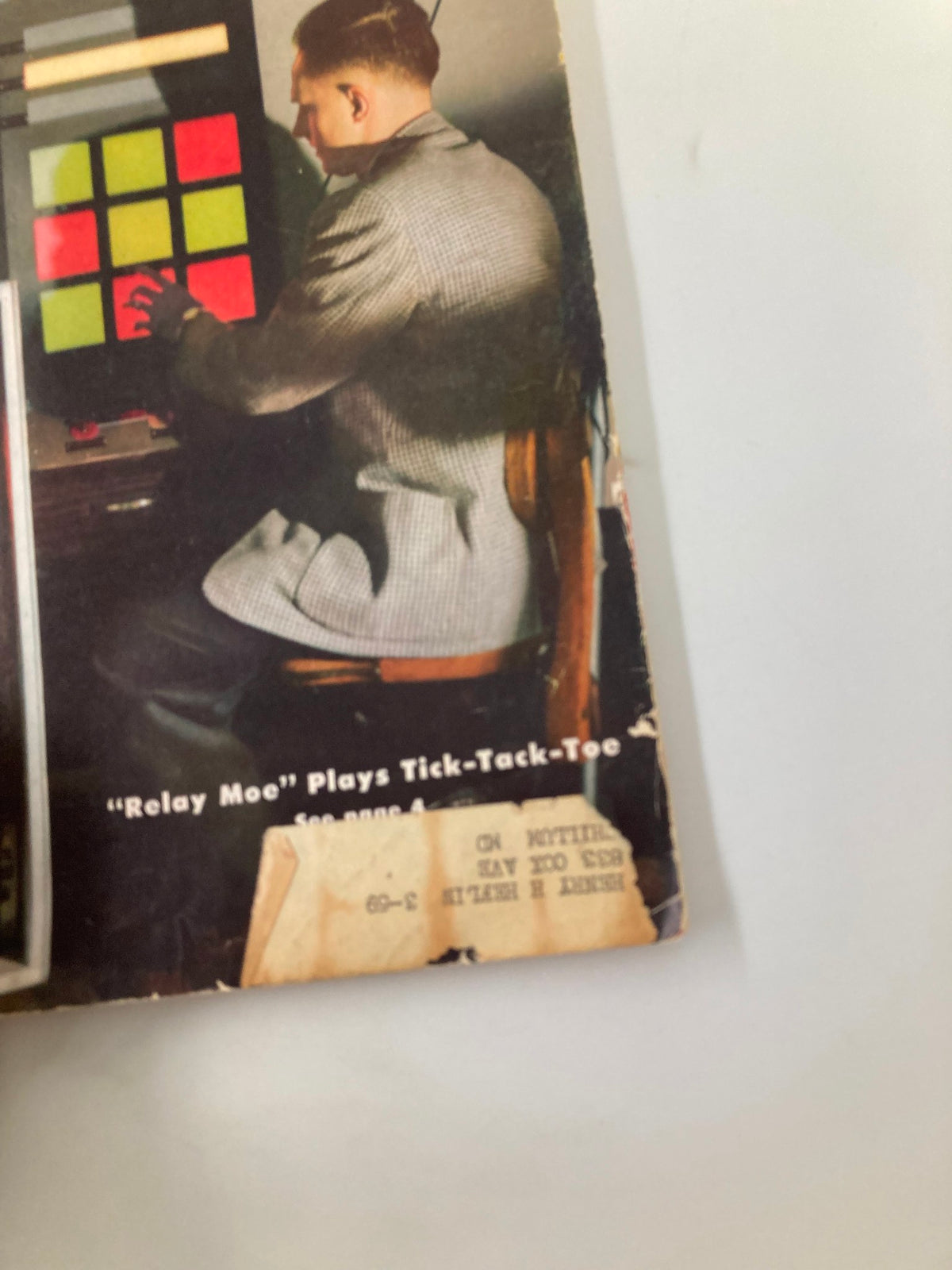 Close-up of a portion of the cover of VTG Radio-Electronics Magazine December 1956, highlighting the DIY game 'Relay Moe' Plays Tick-Tack-Toe and displaying vintage design elements.