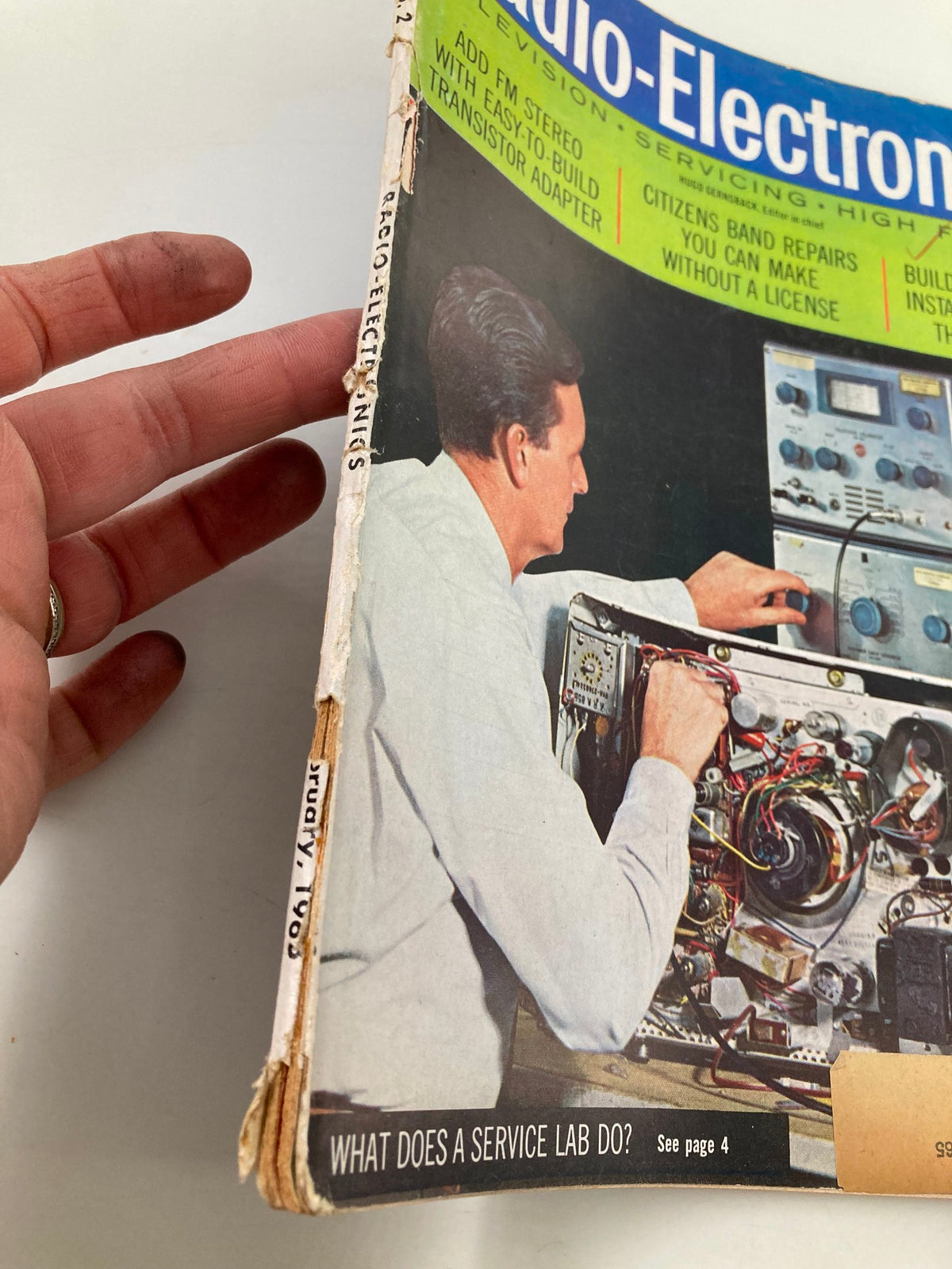 Detailed view of the spine of the VTG Radio-Electronics Magazine February 1963, showing wear and condition with emphasis on the title and article 'What Does A Service Lab Do?'. Vintage magazine appeal evident.