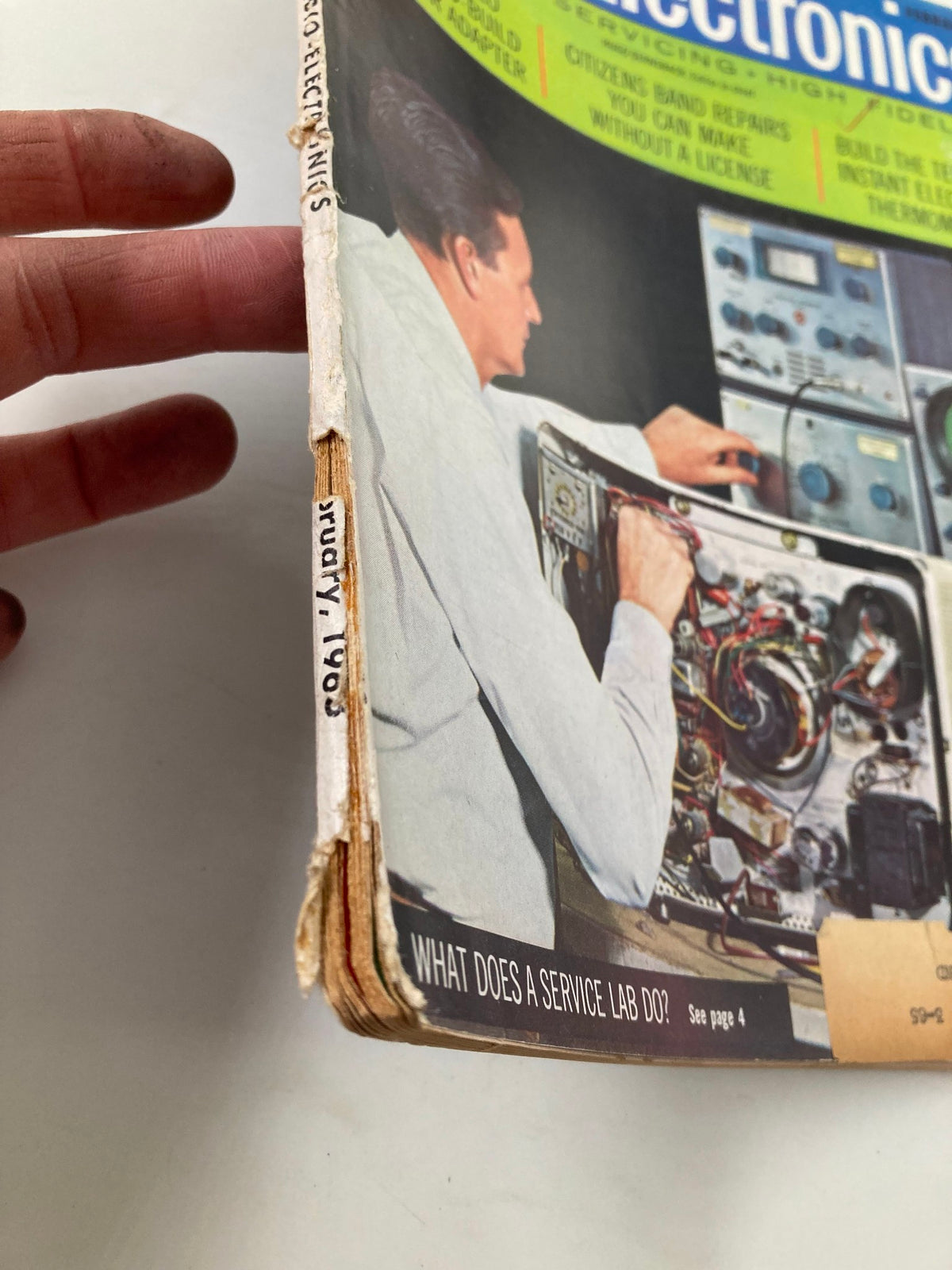 Another angle of the spine of the VTG Radio-Electronics Magazine February 1963, displaying signs of age but maintaining the focus on the title and the featured article 'What Does A Service Lab Do?'.