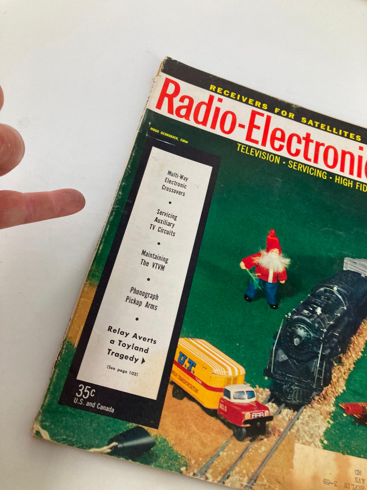 Close-up of the VTG Radio-Electronics Magazine December 1957 cover showing details including toy vehicles and text highlighting articles like "Relay Averts a Toyland Tragedy."