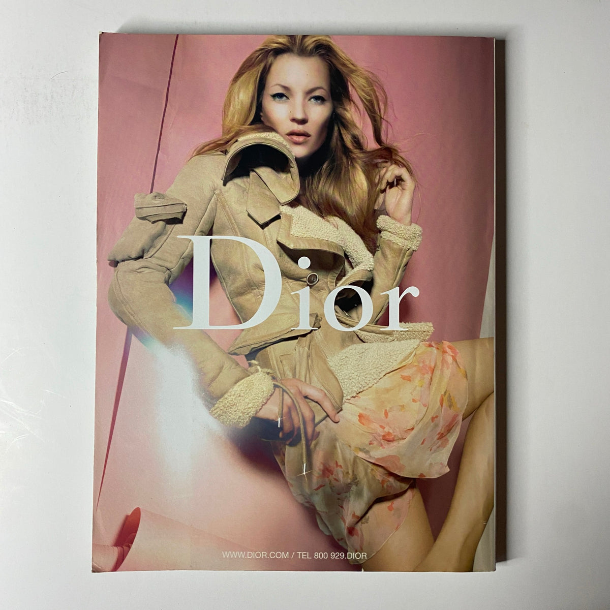 Vogue Magazine August 2005 Dior advertisement featuring a model exuding sophistication in a chic outfit, set against a soft pastel background.