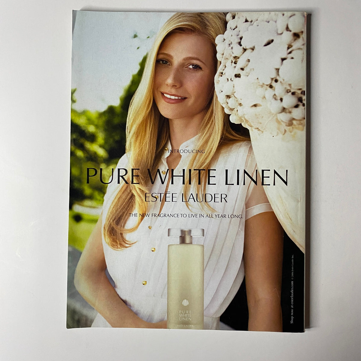 Advertisement page from Vogue Magazine July 2006 for Estee Lauder's Pure White Linen fragrance, featuring a model with a serene expression in a natural setting.
