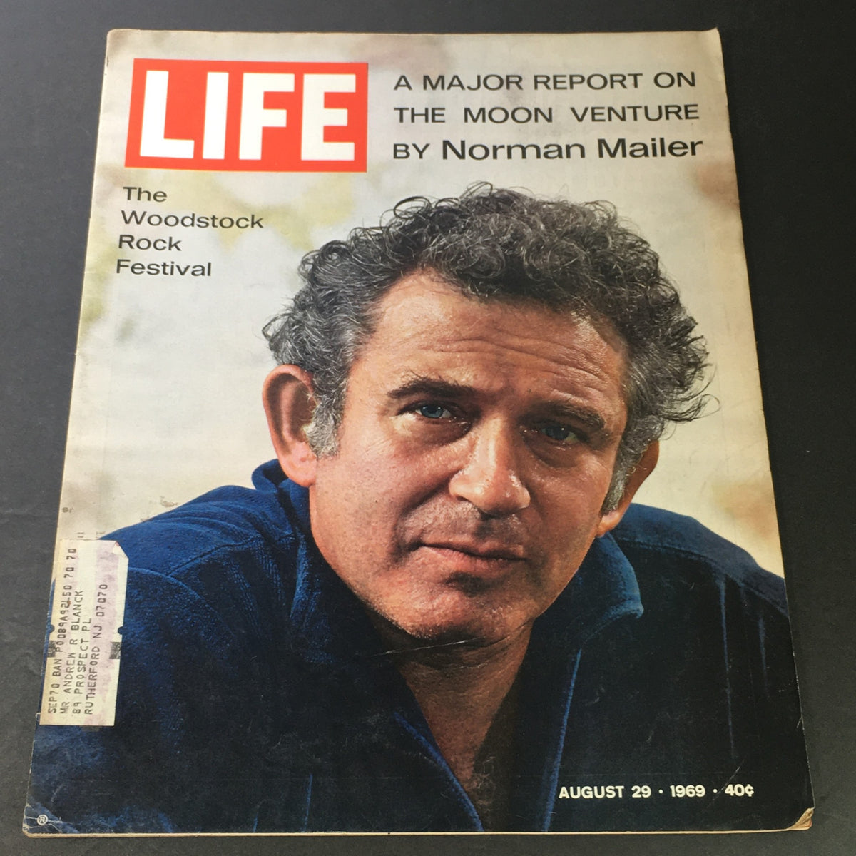 Cover of Life Magazine dated August 29, 1969, featuring 'The Moon Venture' by Norman Mailer, highlighting the Woodstock Festival with an image of a man with curly hair, promoting cultural significance of the 1960s.
