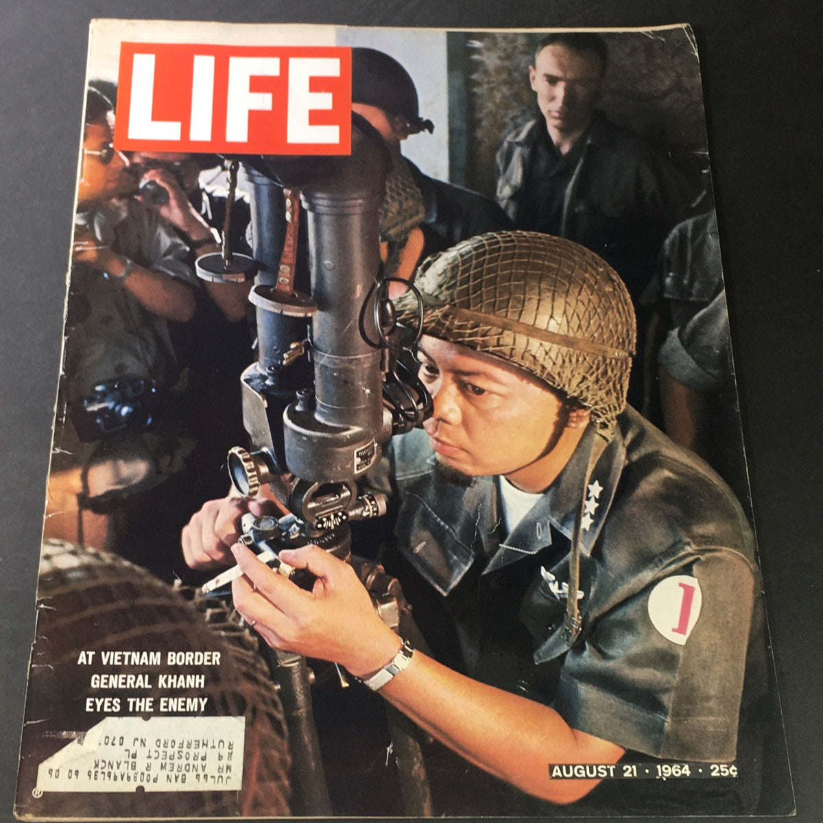Vintage Life Magazine cover from August 21, 1964, featuring the article 'General Nguyễn Khánh Eyes Enemy at Vietnam.' The cover shows a soldier focused on equipment, depicting the military atmosphere of the Vietnam War era.