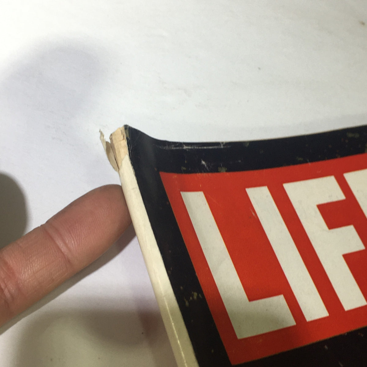 Close-up of the damaged corner of the Vintage Life Magazine April 30, 1965, demonstrating its good and used condition.