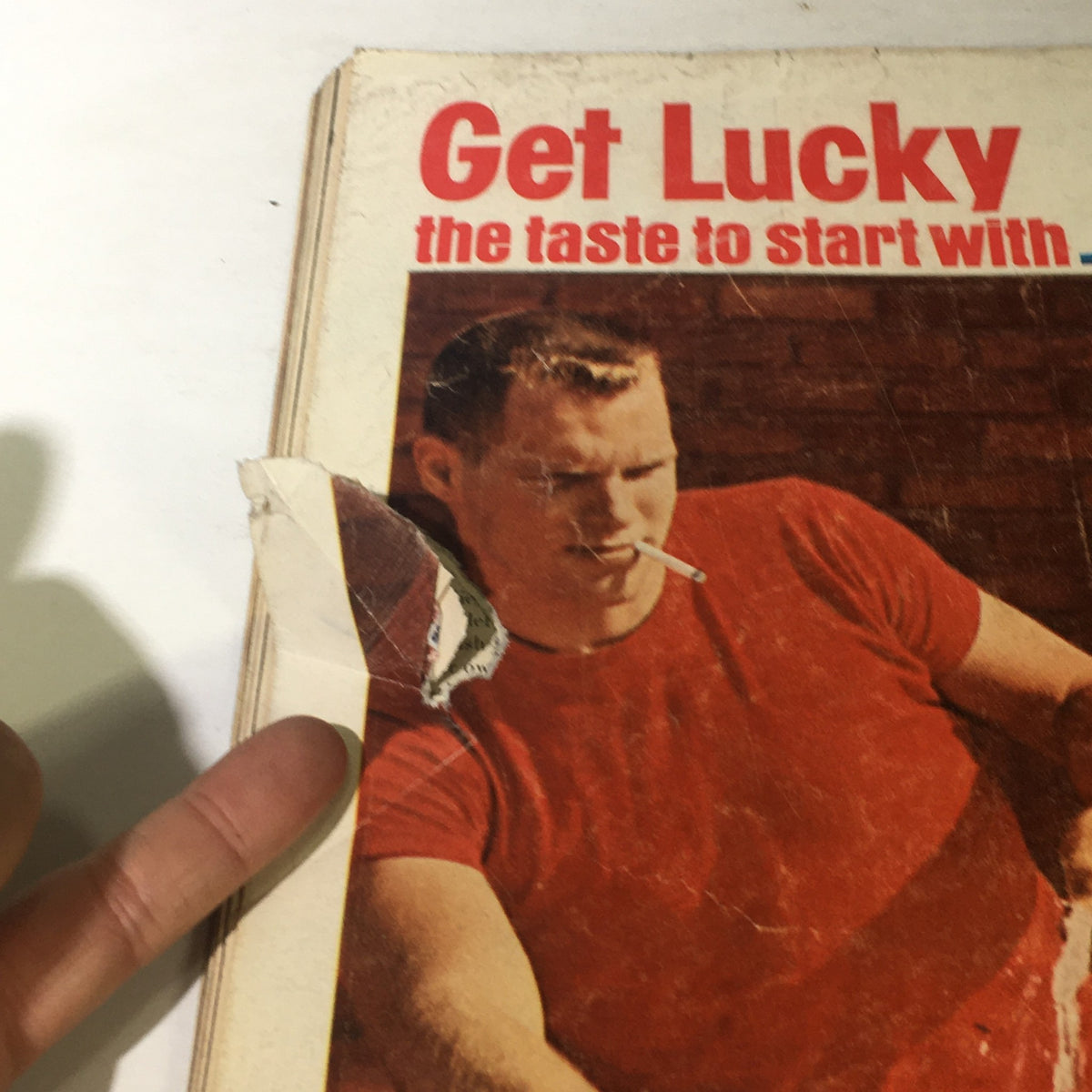 Close-up of the damaged edge of VTG Life Magazine April 27 1962 showing a man with a cigarette, illustrating wear from age.