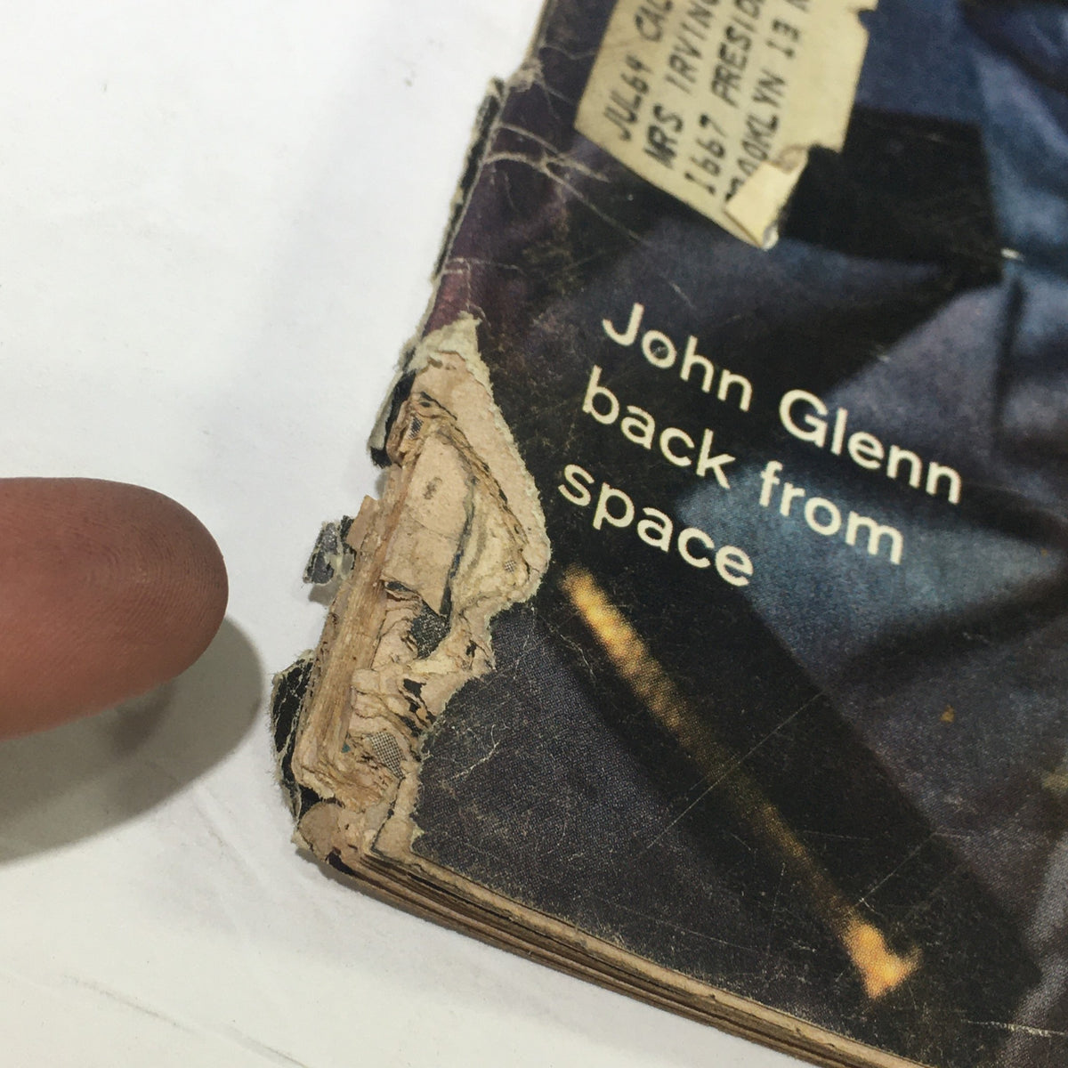 Close-up of the damaged cover corner of the VTG Life Magazine March 2 1962 featuring John Glenn, highlighting signs of wear from age.
