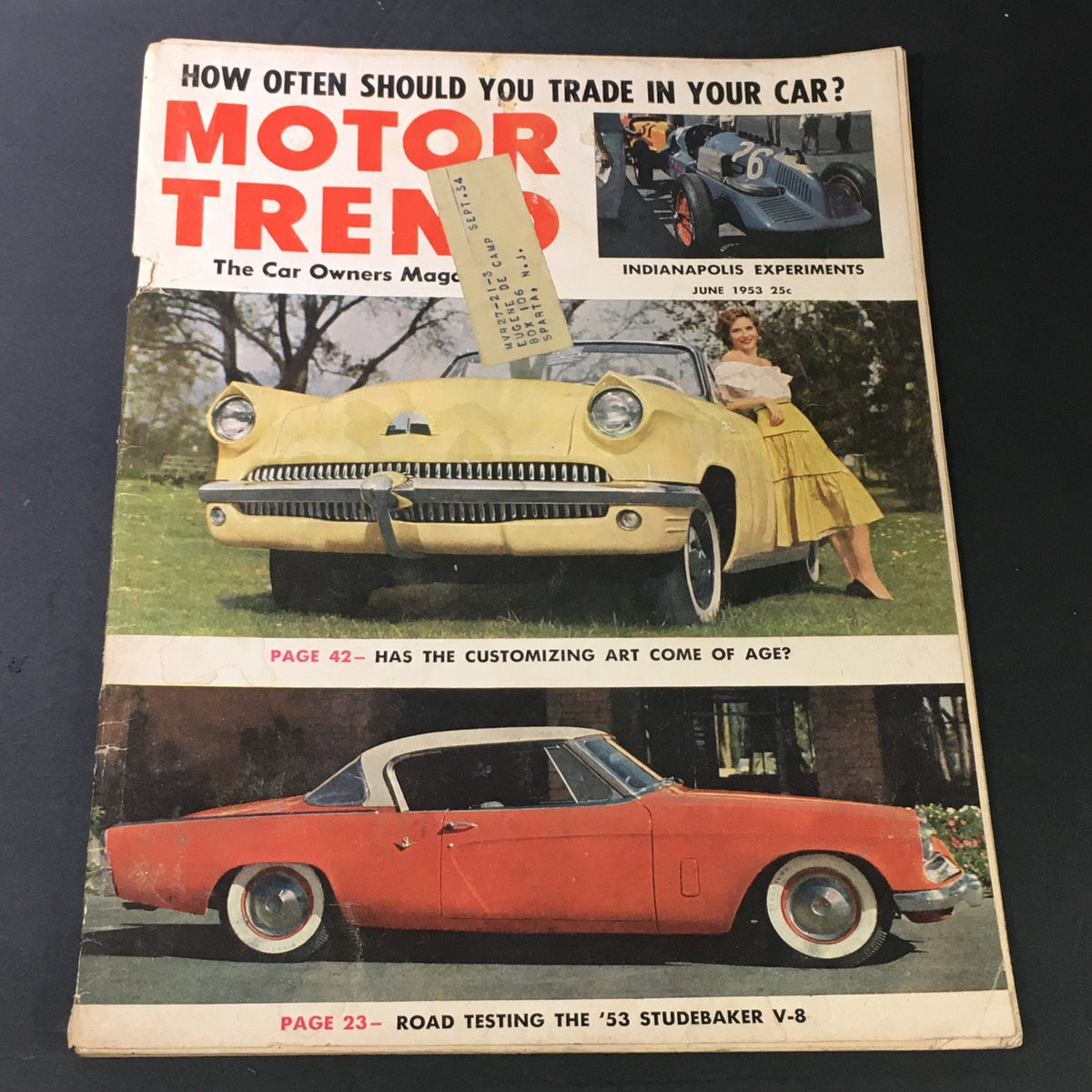 Cover of VTG Motor Trend Magazine June 1953 featuring a yellow car and woman, along with the headline 'Road Testing the 53 Studebaker V-8'.