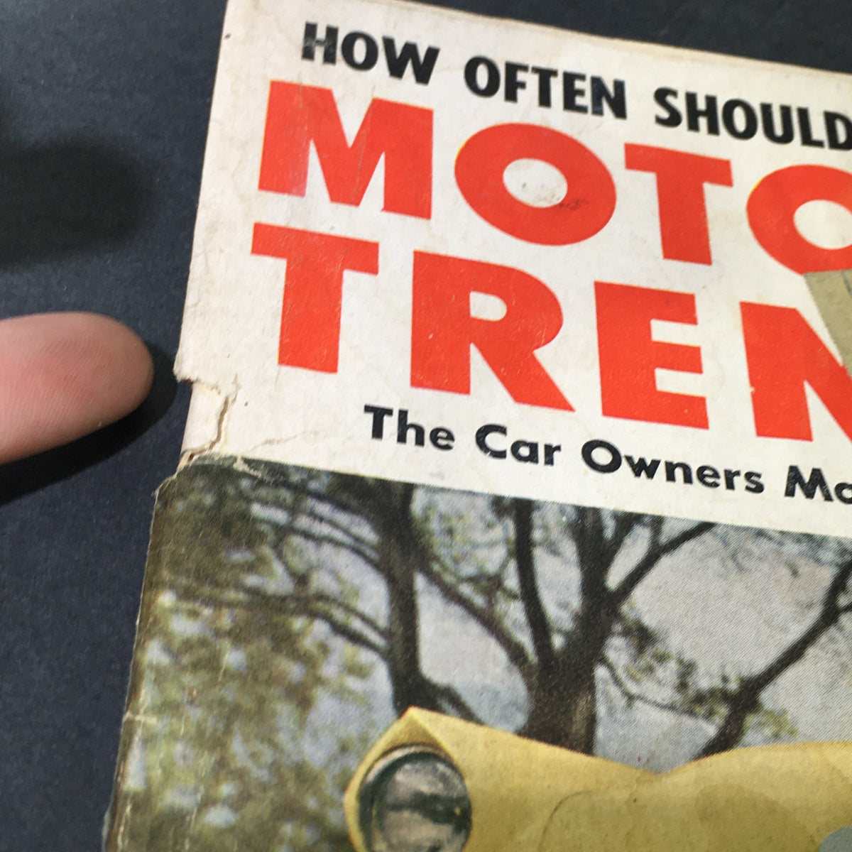 Close-up of the title 'Motor Trend' on the June 1953 magazine cover, showing wear and age, part of the VTG Motor Trend Magazine June 1953 collection.