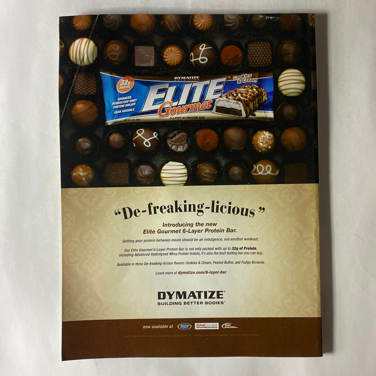 Back cover of Fitness RX Magazine March 2010 showcasing the Dymatize Elite Gourmet 6-Layer Protein Bar ad with assorted chocolates.