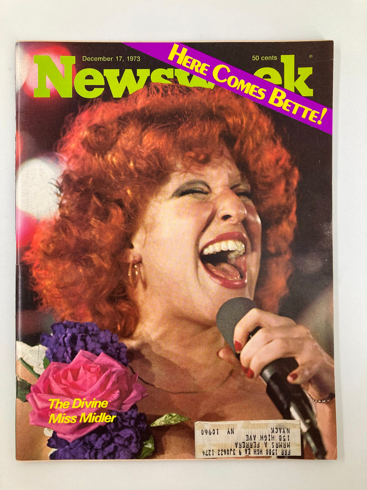 Vintage Newsweek magazine cover from December 17, 1973, featuring the title 'Here Comes Bette: The Divine Miss Midler.' The cover showcases a vibrant image of Bette Midler performing, adorned with a colorful floral arrangement. Ideal for collectors and enthusiasts of 1970s pop culture.