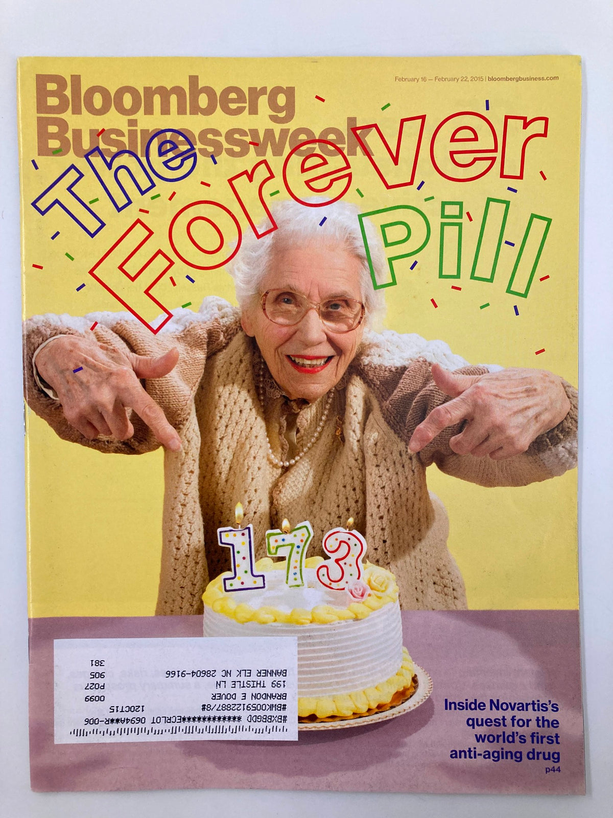 Cover of Bloomberg Businessweek Magazine from February 16, 2015, featuring an elderly woman holding a cake with the title 'The Forever Pill' highlighting the world's first anti-aging drug.