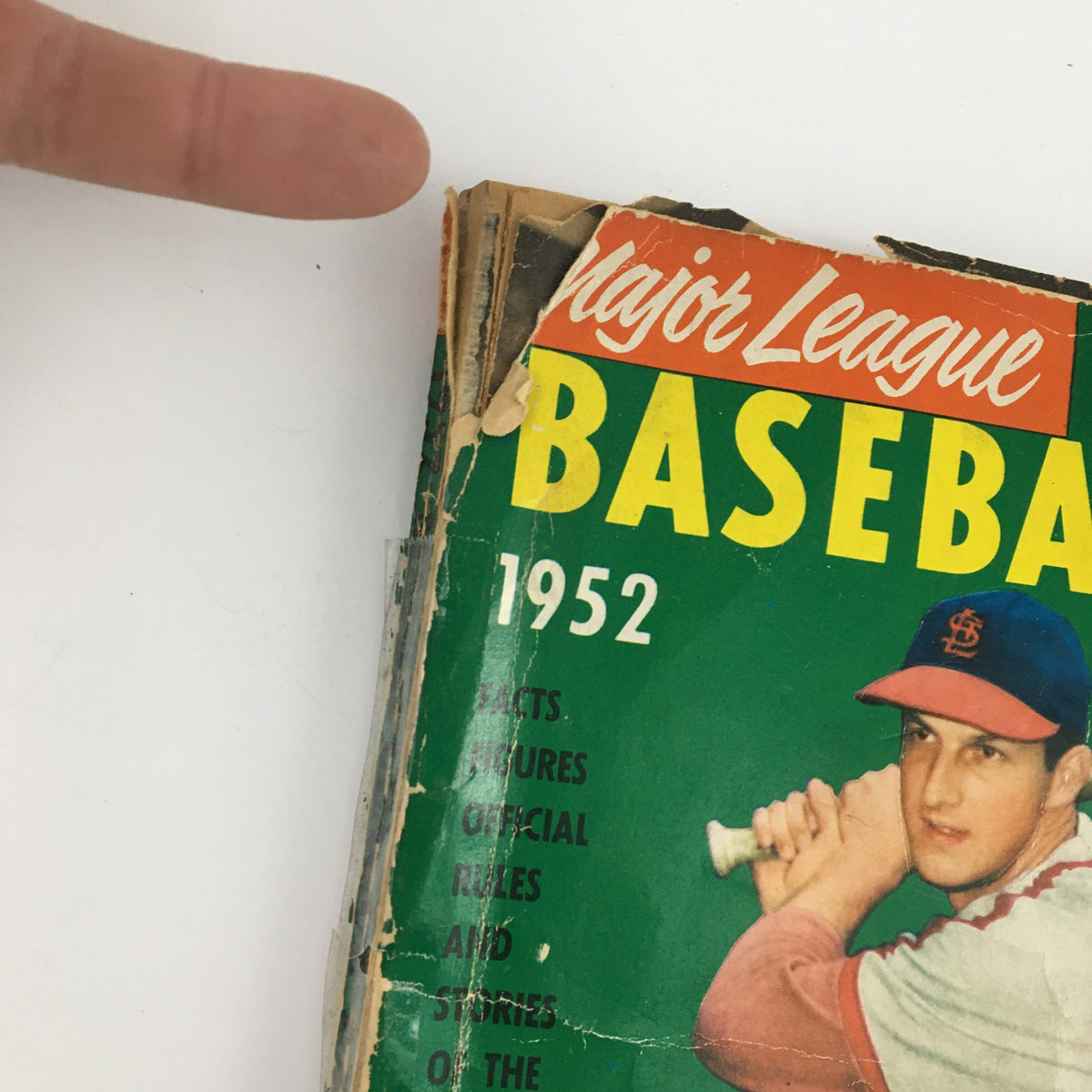 Cover of the 1952 Major League Baseball Official Rules & Stories, featuring a worn design and Stanley Musial's name, showcasing vintage baseball memorabilia.