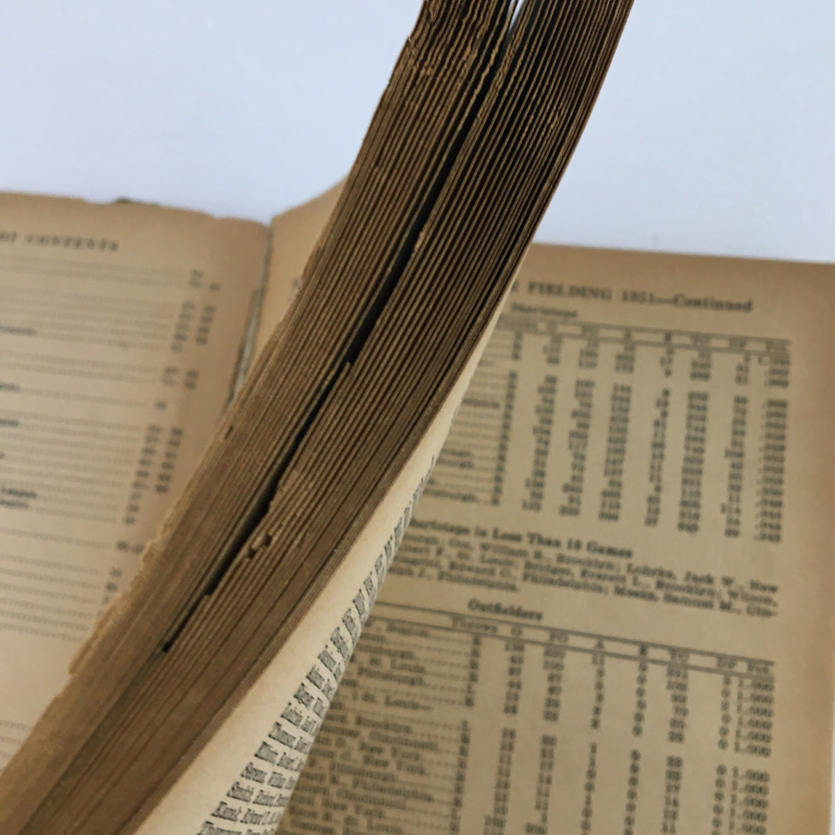 Close-up view of the pages of the 1952 Major League Baseball Official Rules & Stories, showcasing aged and worn pages.