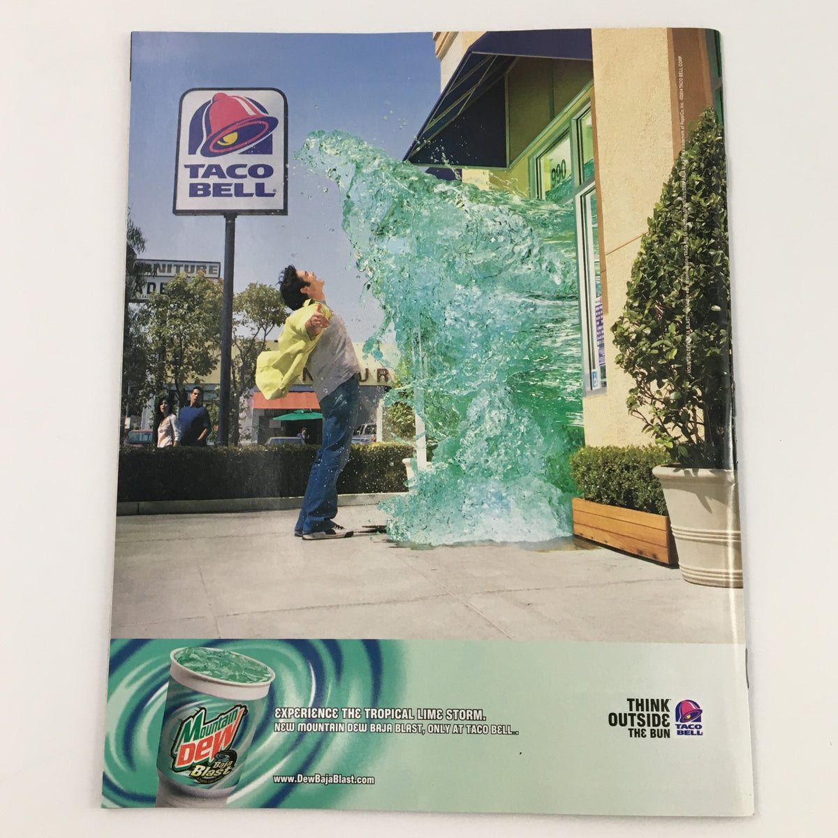 WWE Smack Down Magazine September 2004 featuring an advertisement for Taco Bell with a surreal imagery of a person interacting with a large wave of Mountain Dew, presenting a unique promotional concept.