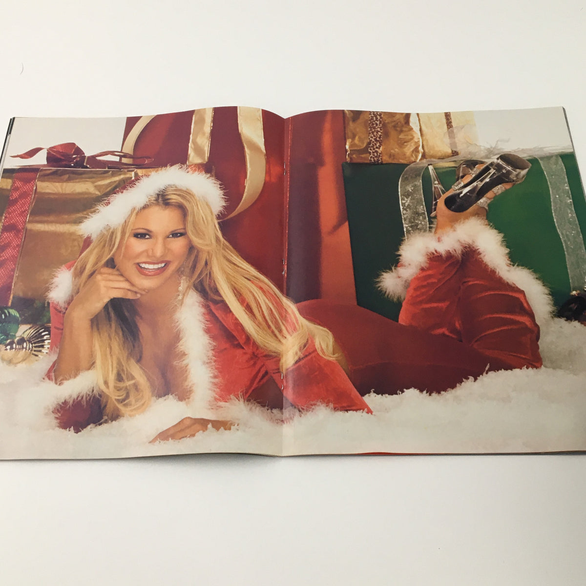 Inside the WWE Smack Down Holiday 2004 magazine, showcasing a festive photo of Torrie in a Santa outfit, surrounded by Christmas gifts.