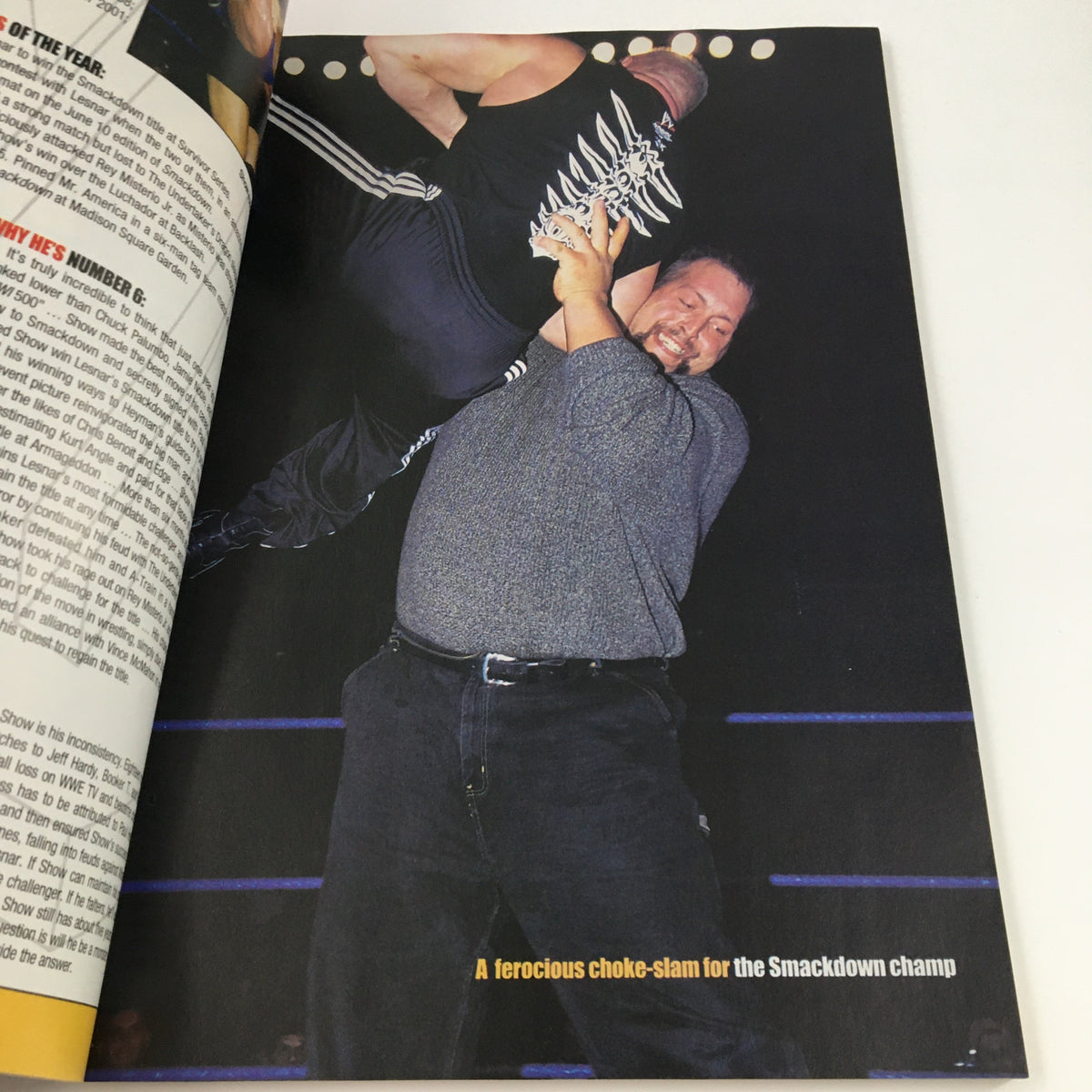 A wrestler performing a choke-slam, emphasizing the intense competition in WWE, as featured in Pro Wrestling Illustrated Magazine Fall 2003.