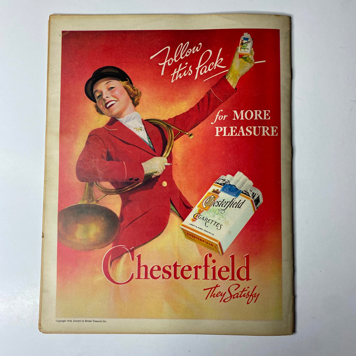 Vintage ad for Chesterfield cigarettes featured in Look Magazine March 15, 1938, showcasing a woman in red attire promoting the brand with the tagline 'Follow this Pack for More Pleasure'.