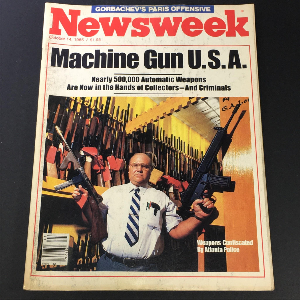 Cover of Vintage Newsweek magazine from October 14, 1985, titled 'Machine Gun U.S.A.', featuring an individual holding firearms in front of a backdrop of weapons confiscated by Atlanta police.
