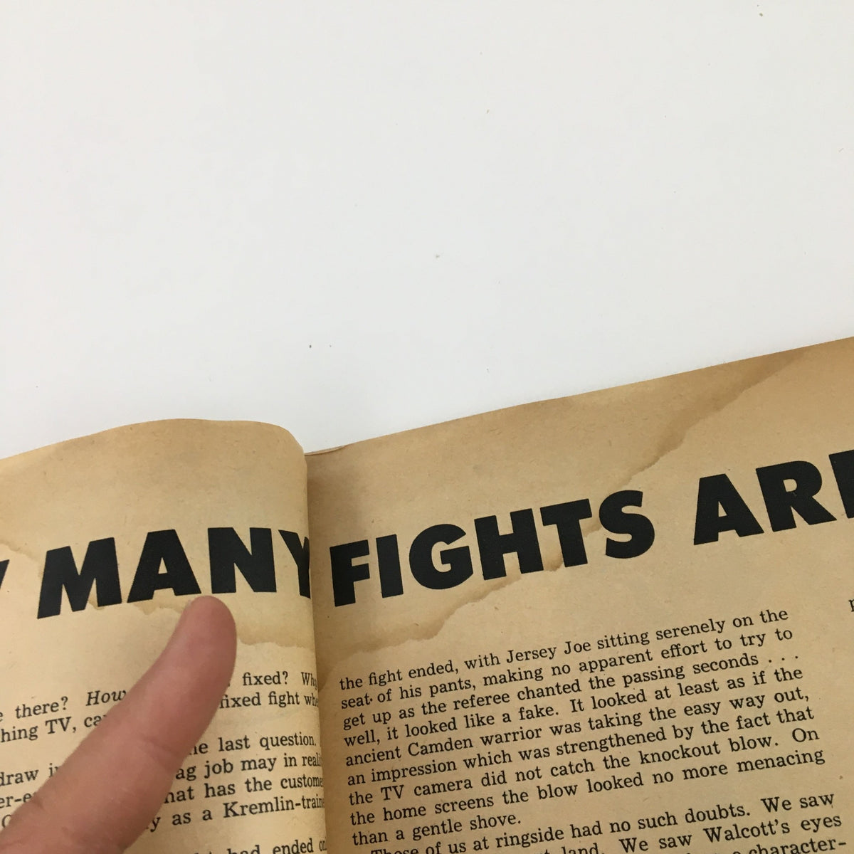 Close-up of an open page from Disney News Magazine Summer 1985 showing the text 'How Many Fights Are' with a finger pointing towards the article, showcasing vintage magazine content.