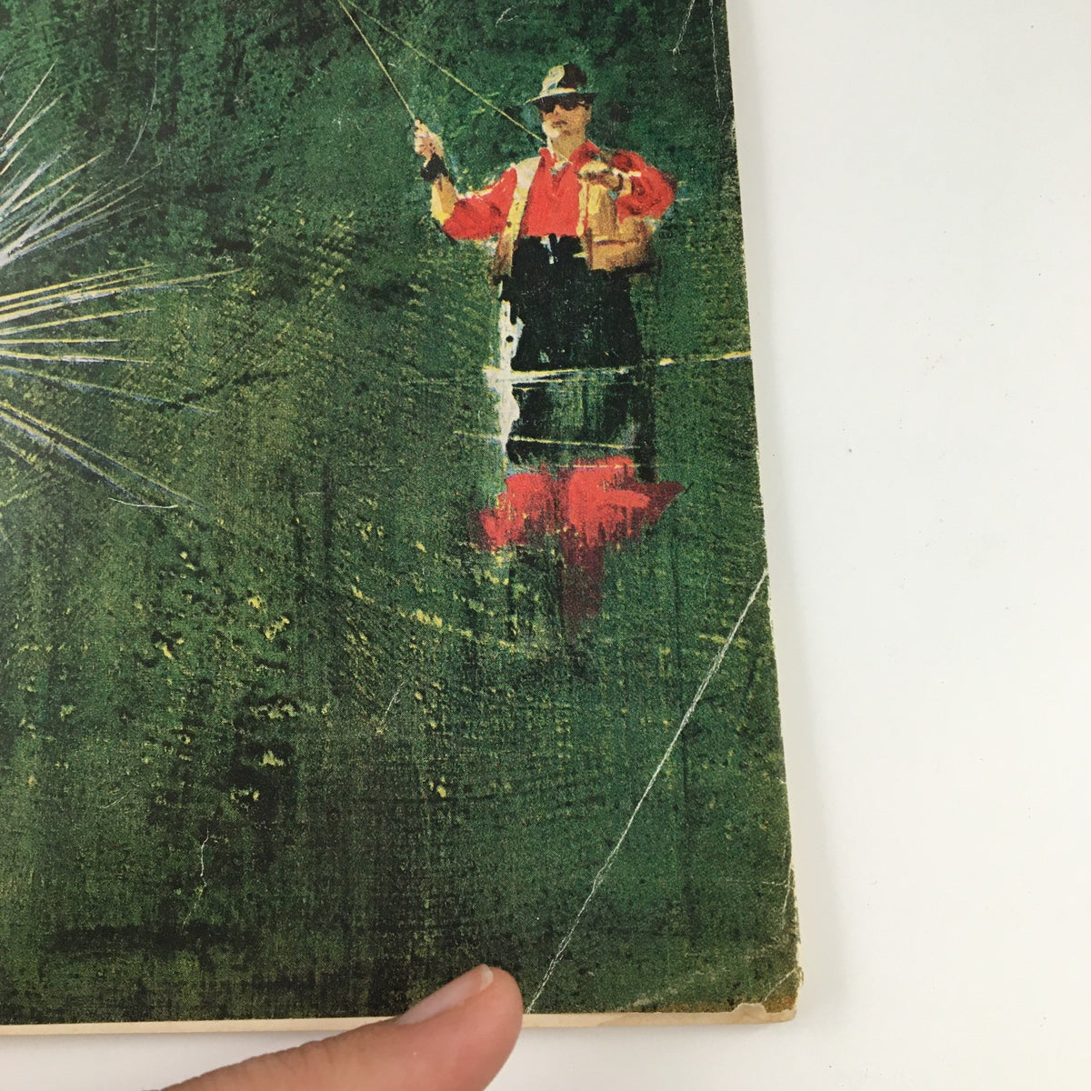 Close-up of the cover of Sports Illustrated Magazine from July 8, 1963, highlighting the fisherman and fishing fly artwork, part of the cover story featuring amateur caster Jon Torentino.