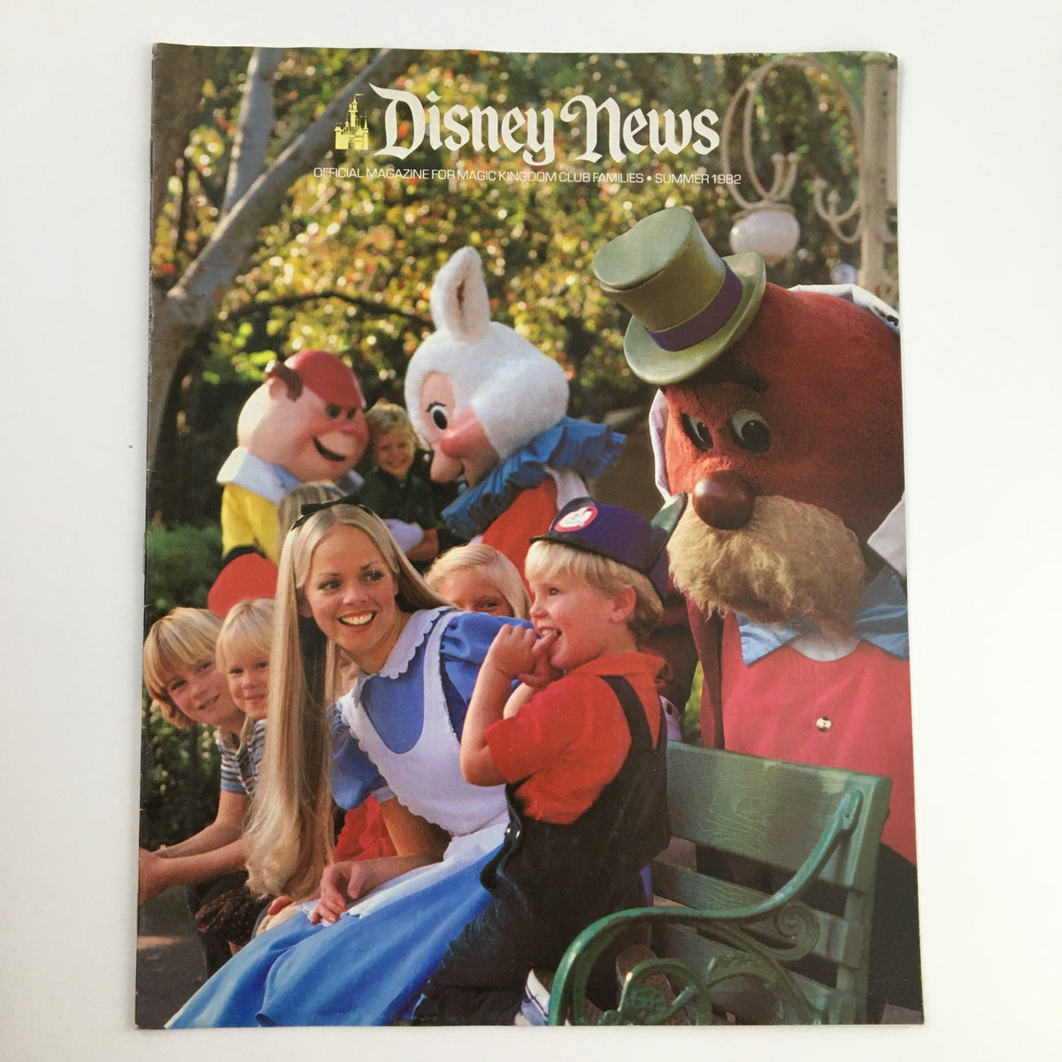 Disney News Magazine Summer 1982 cover featuring Alice in Wonderland and Disneyland Park characters, illustrating a joyful gathering of children and Disney characters.