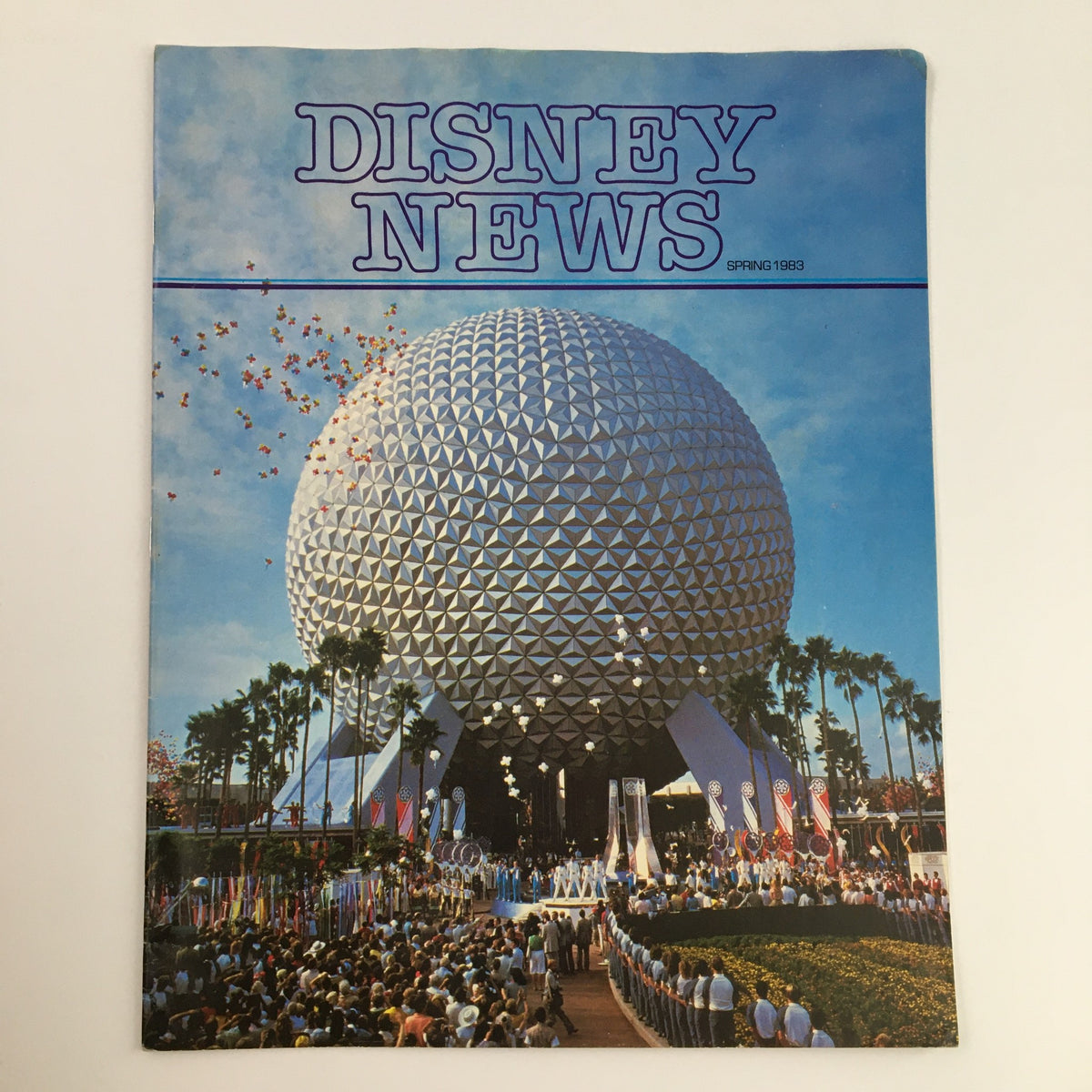 Cover of Disney News Magazine Spring 1984 featuring a vibrant image of Epcot Center, colorful flowers, and audience celebrating the arrival of spring, highlighting the theme 'Things That Go Bloom In The Spring.'