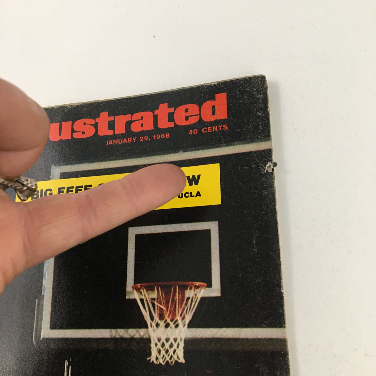 Close-up of the Sports Illustrated Magazine January 29 1968 cover, emphasizing the headline 'BIG EEEE OVER BIG LEW' regarding the UCLA upset, with a basketball hoop in the background.