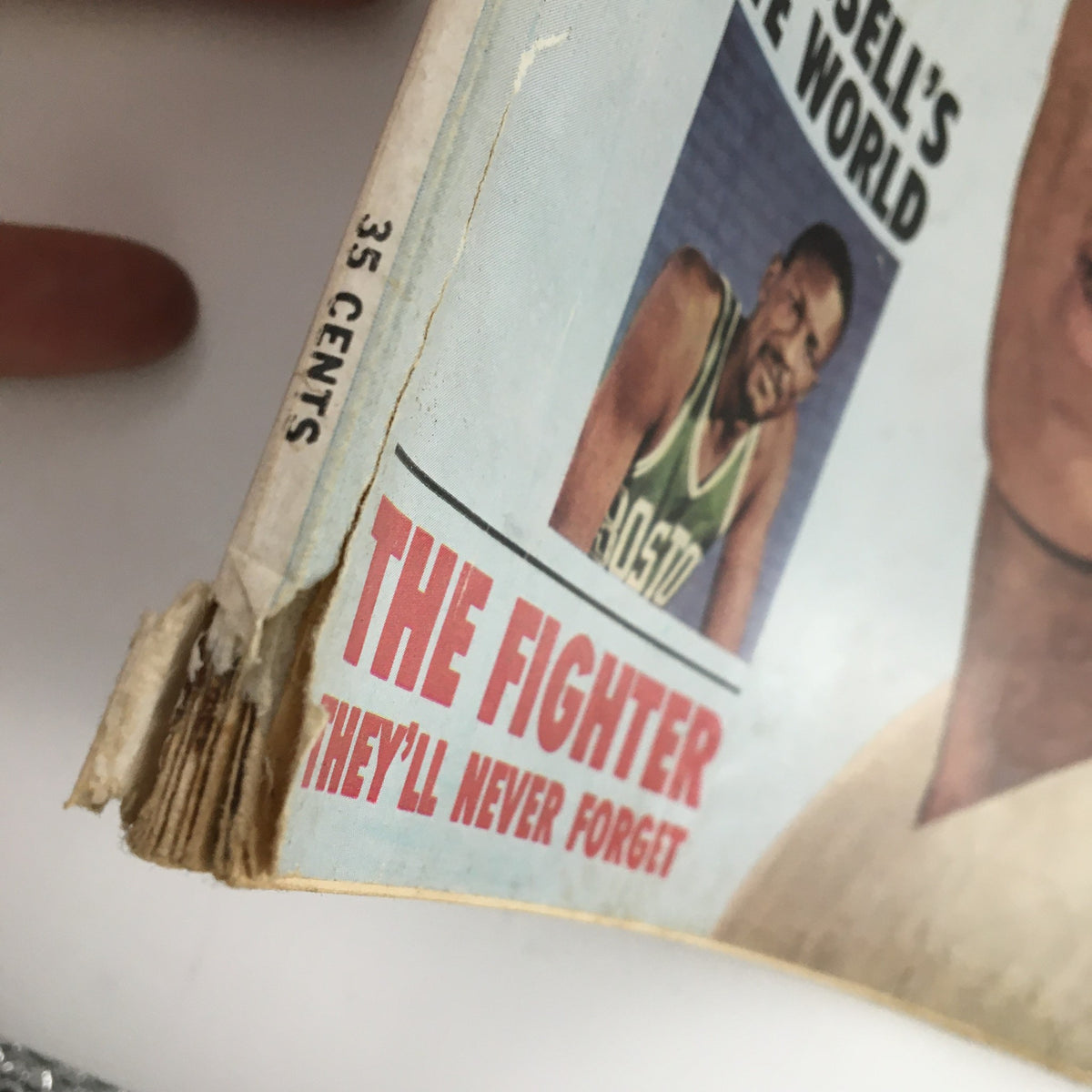 Close-up view of the edge of the February 1963 issue of Sport Magazine featuring the price '35 cents' and the tagline 'THE FIGHTER THEY'LL NEVER FORGET'. This magazine showcases notable athletes like Maury Wills, Bill Russell, and Jimmy Piersall.
