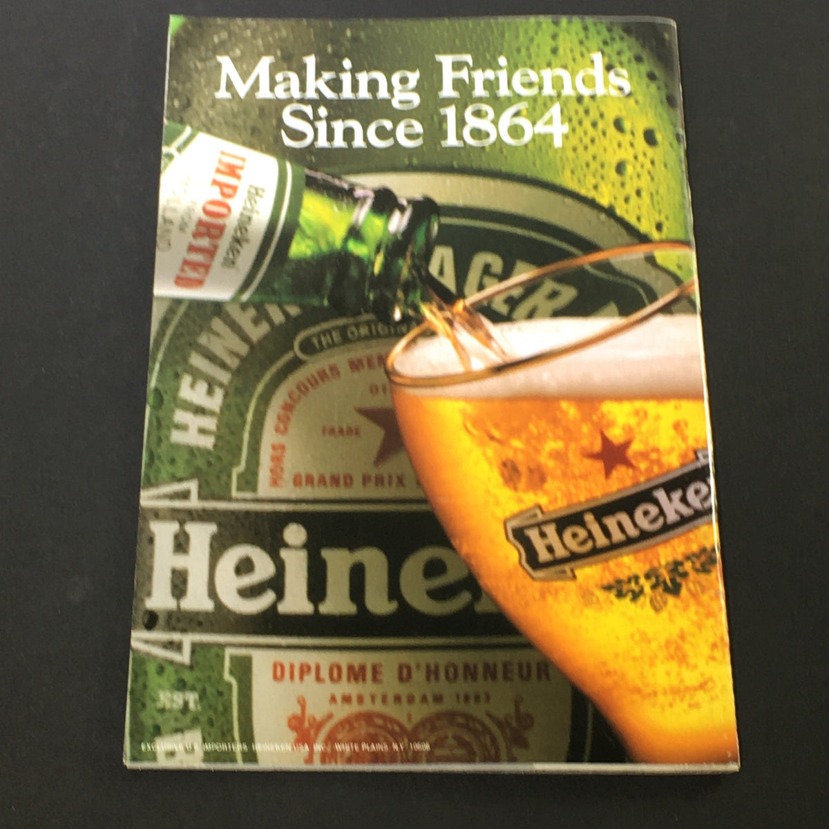 Cover page of a vintage Heineken advertisement with the tagline 'Making Friends Since 1864,' showcasing a beer bottle and a glass.