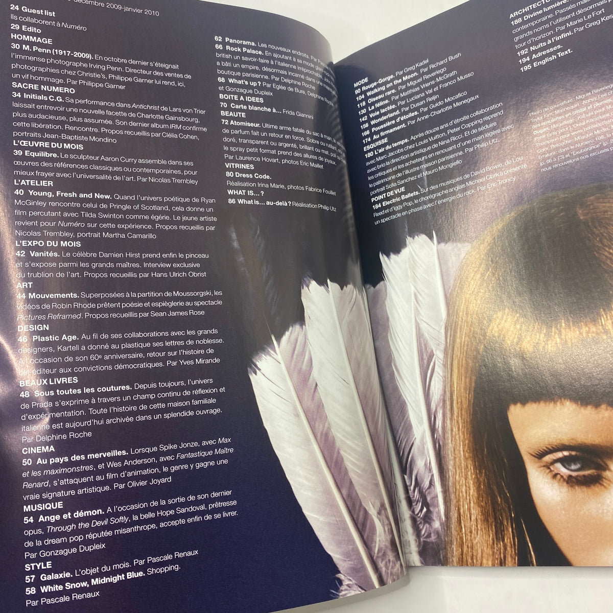 Interior page from Numéro Magazine December 2009 No. 109 featuring an article listing and eye-catching fashion photography with feathers, showcasing modern styles.