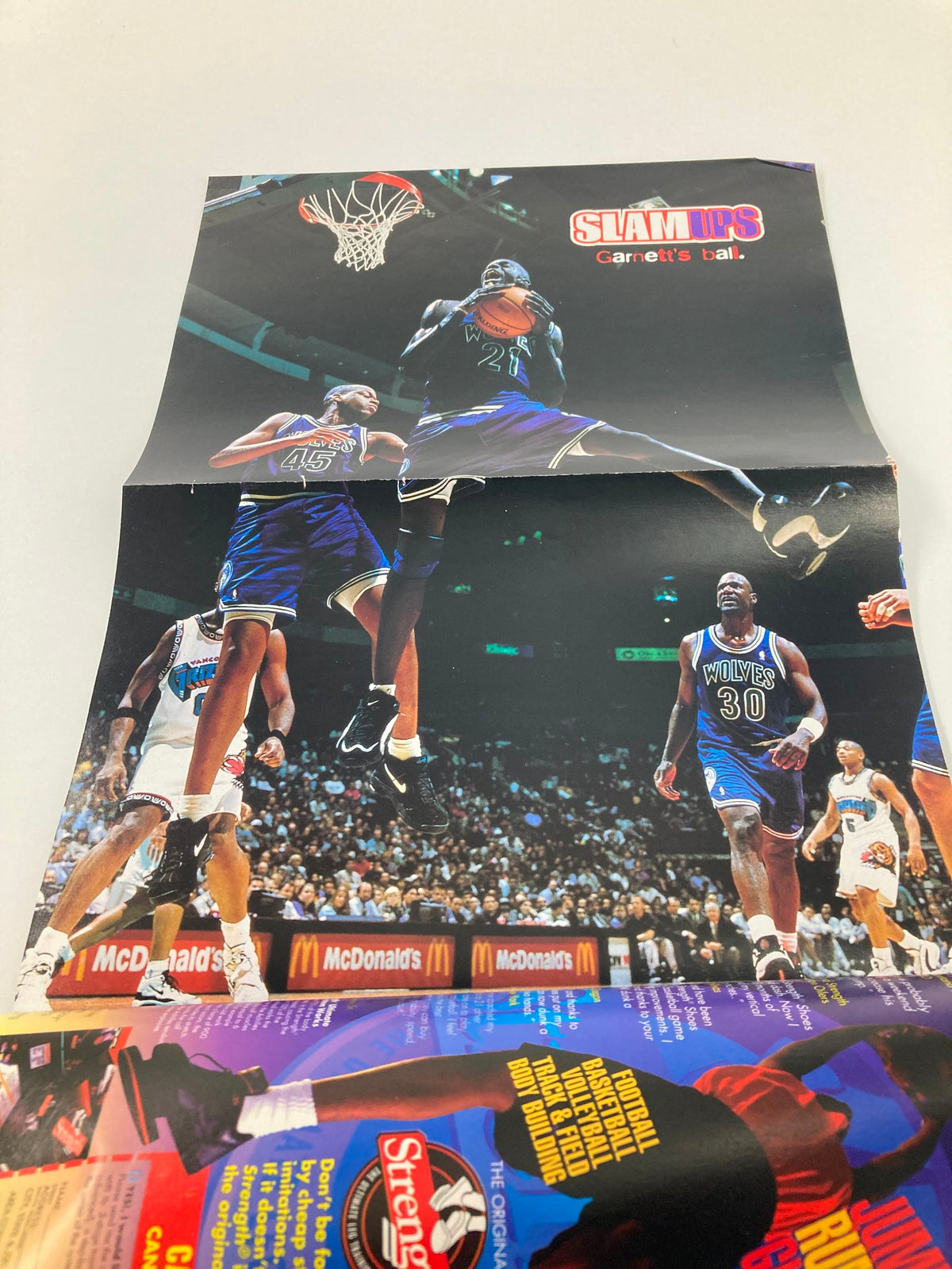 Slam Magazine March 1996 Chicago Bulls Scottie Pippen showcasing a poster of NBA player Kevin Garnett in action.