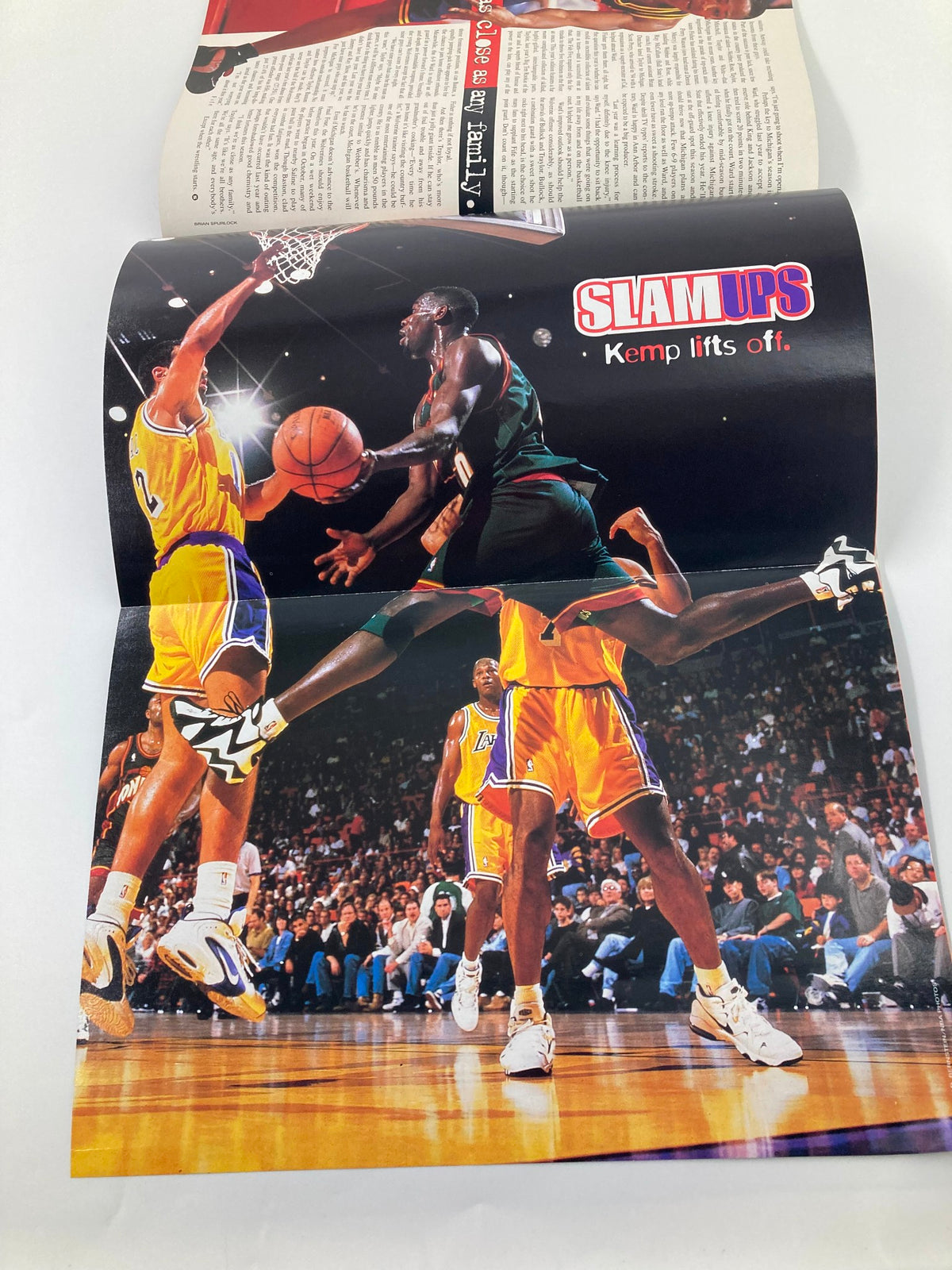 Slam Magazine March 1996 Chicago Bulls Scottie Pippen displaying a poster of NBA player Shawn Kemp making an impressive dunk.