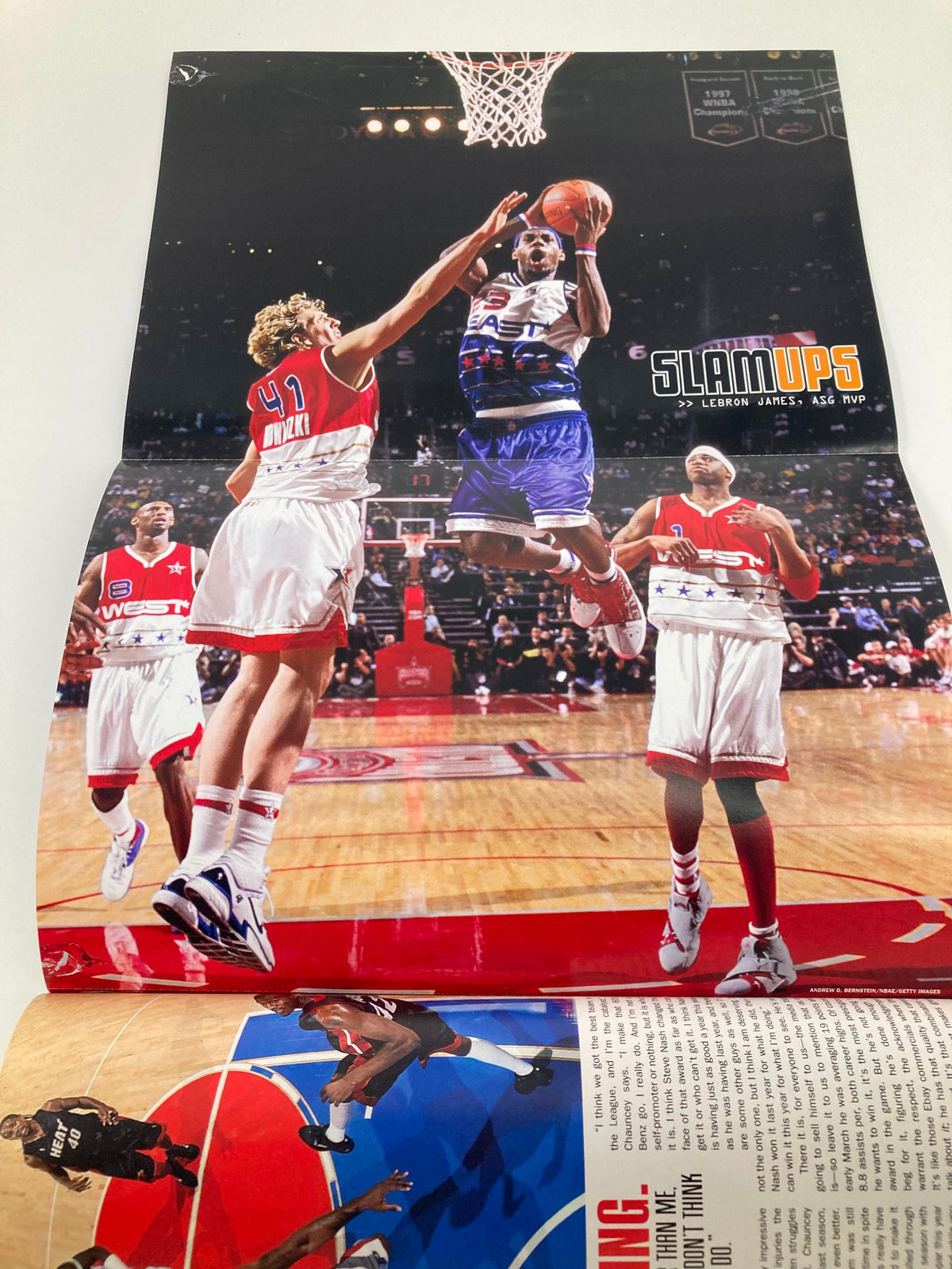 Image from Slam Magazine June 2006 featuring Chauncey Billups, showcasing a dynamic basketball moment with LeBron James making a slam dunk during an NBA event. This collectible magazine captures sports history and highlights Billups' role as NBA Finals MVP.