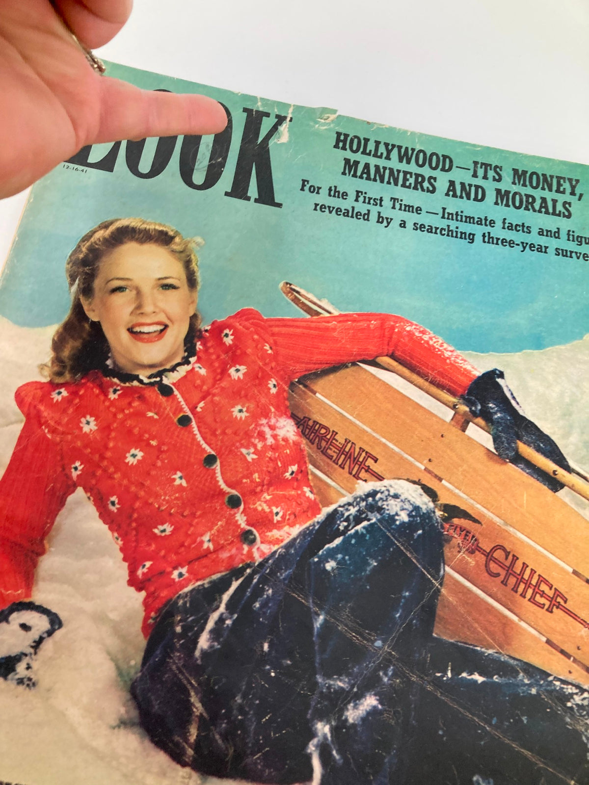 Close-up of the cover of VTG Look Magazine December 16, 1941 showcasing Barbara Britton smiling in a red sweater, with text highlighting Hollywood culture and manners.