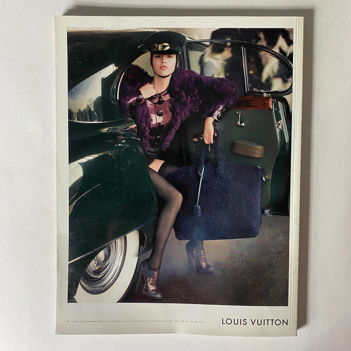 Advertisement for Louis Vuitton within Numéro Magazine August 2011 No. 125, featuring a model by a vintage car.