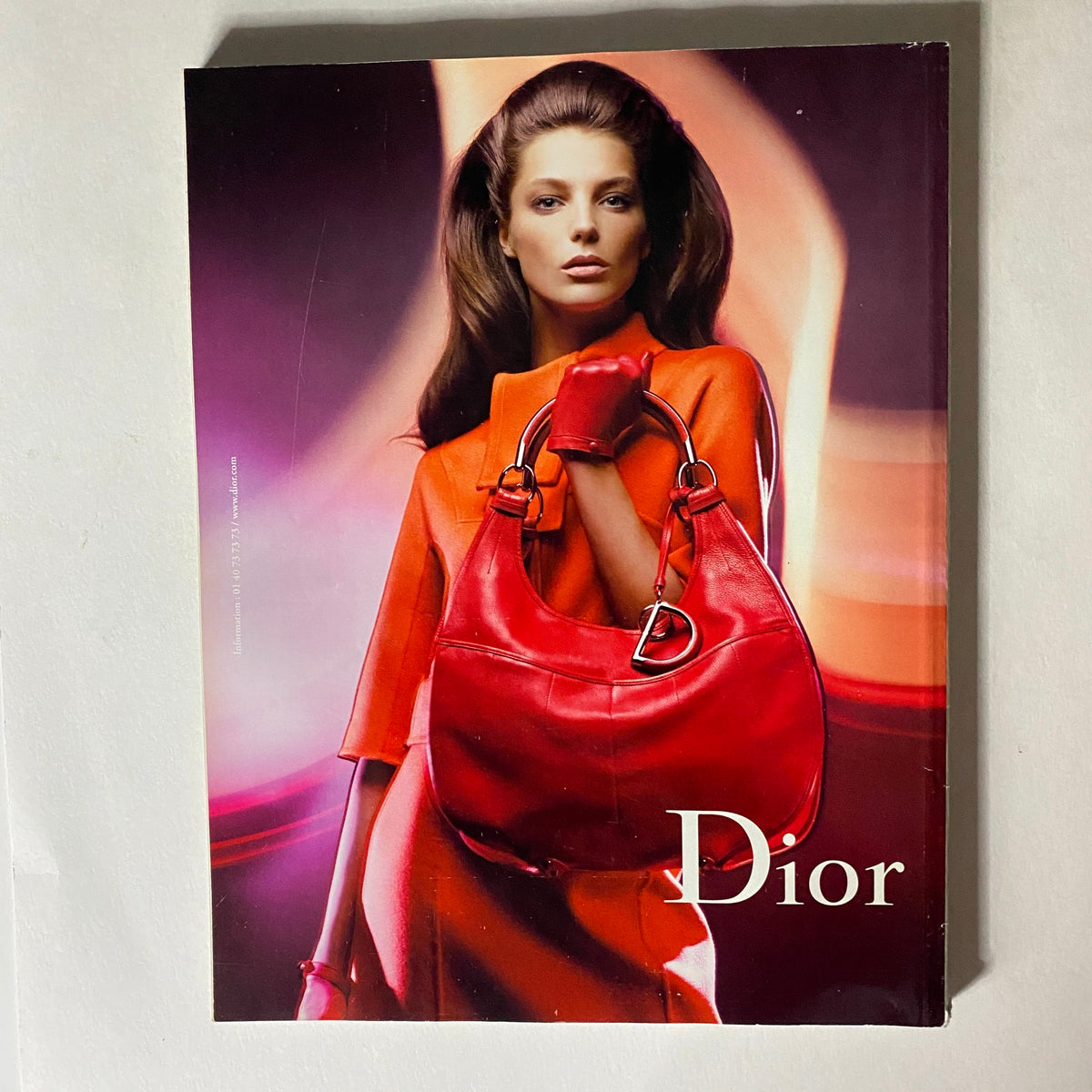 Promotional page from Vogue Paris Magazine August 2008 showcasing a model with a red handbag, representing Dior's high-end fashion.
