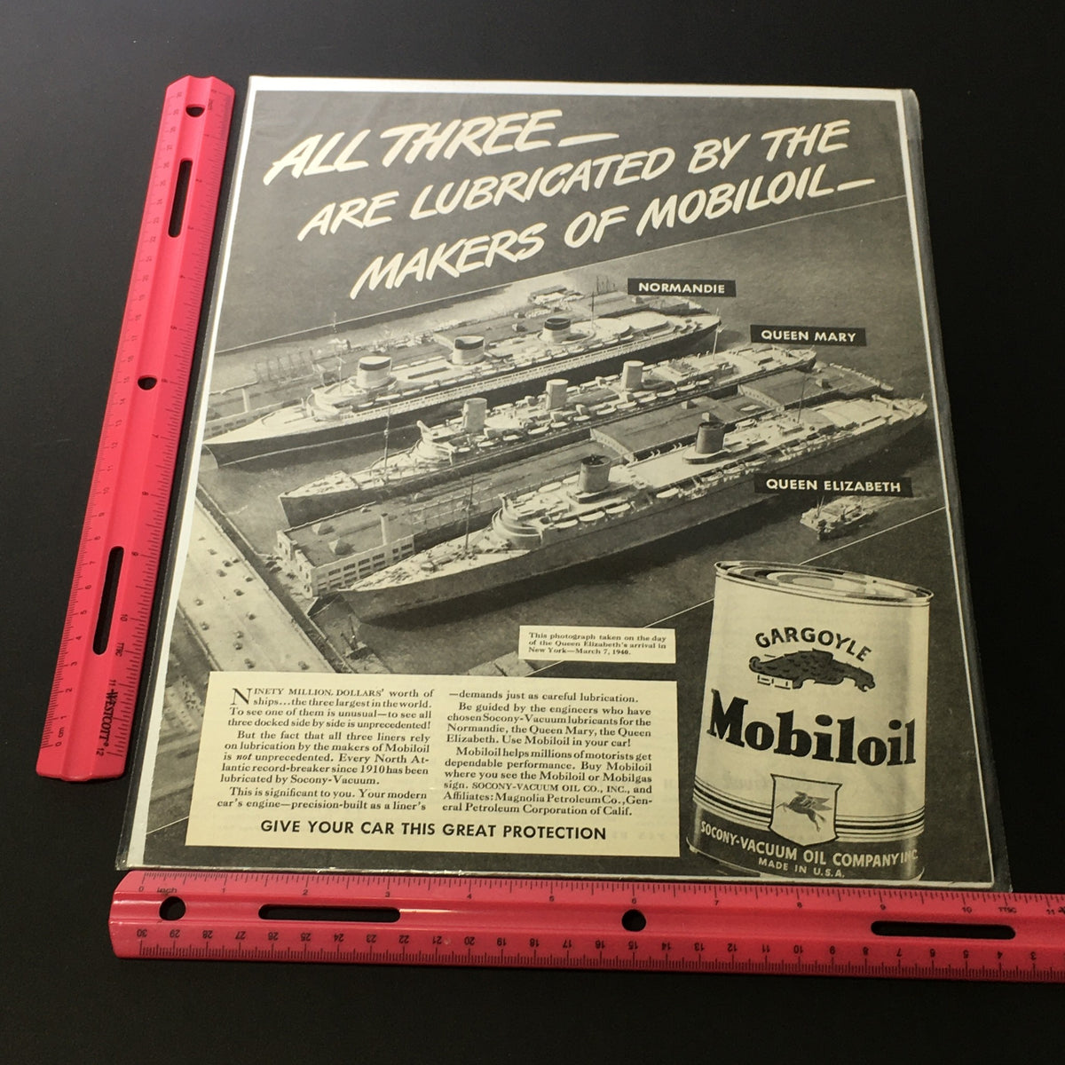 VTG 1940 Gargoyle Mobiloil Print Ad with a ruler for scale, featuring ships Normandie, Queen Mary, and Queen Elizabeth.