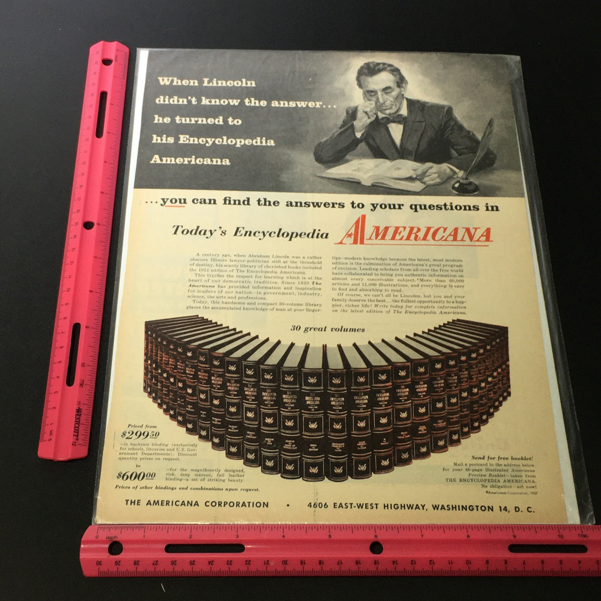 Close-up view of the VTG 1957 The Americana Corporation Encyclopedia Abraham Lincoln Print Ad, including a ruler for size reference, displaying the ad's details prominently.