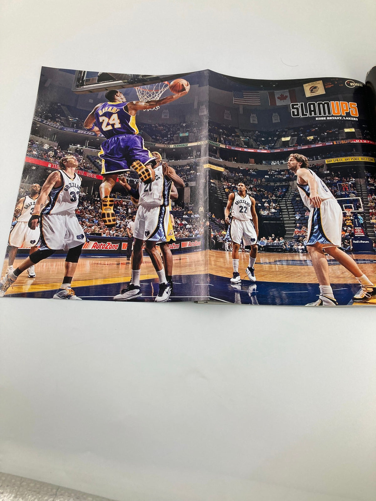 Double-page image in Slam Magazine July 2007 showing a dramatic basketball play, with players on the court, capturing the excitement of NBA games.