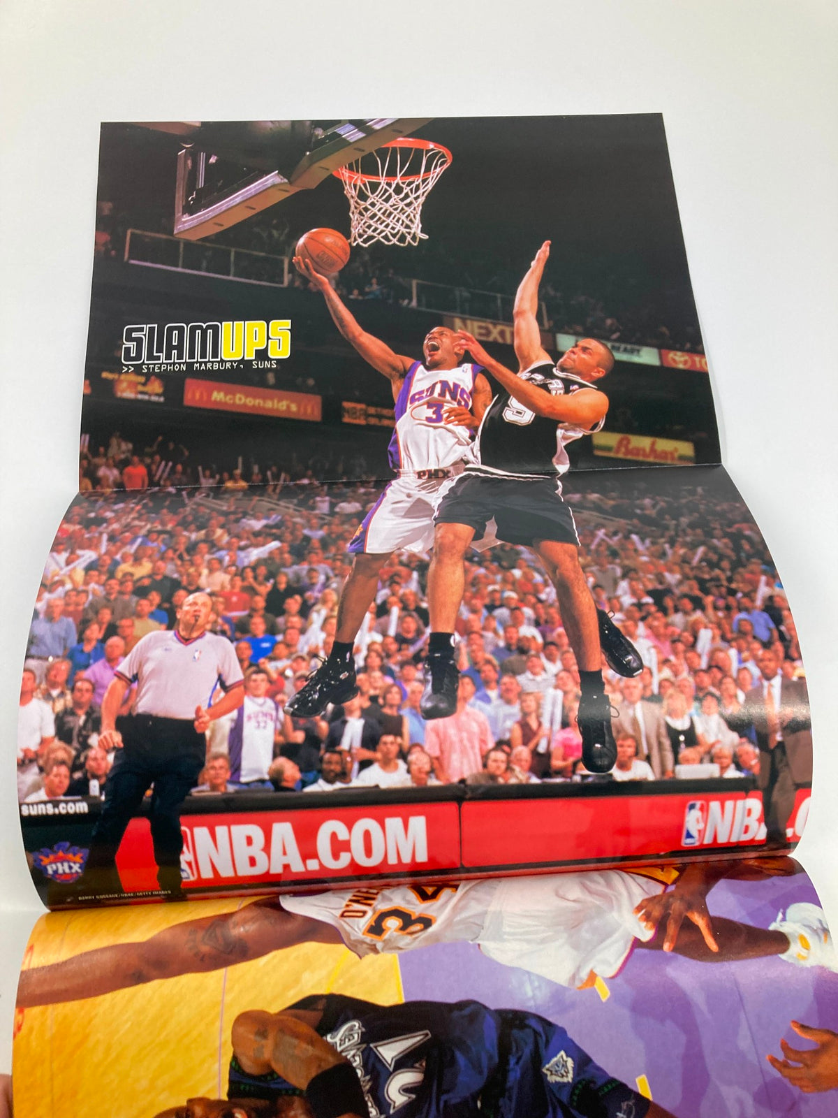 Slam Magazine August 2003 featuring LeBron James, displaying a dramatic moment of a basketball player making a shot, captured in a vibrant poster.