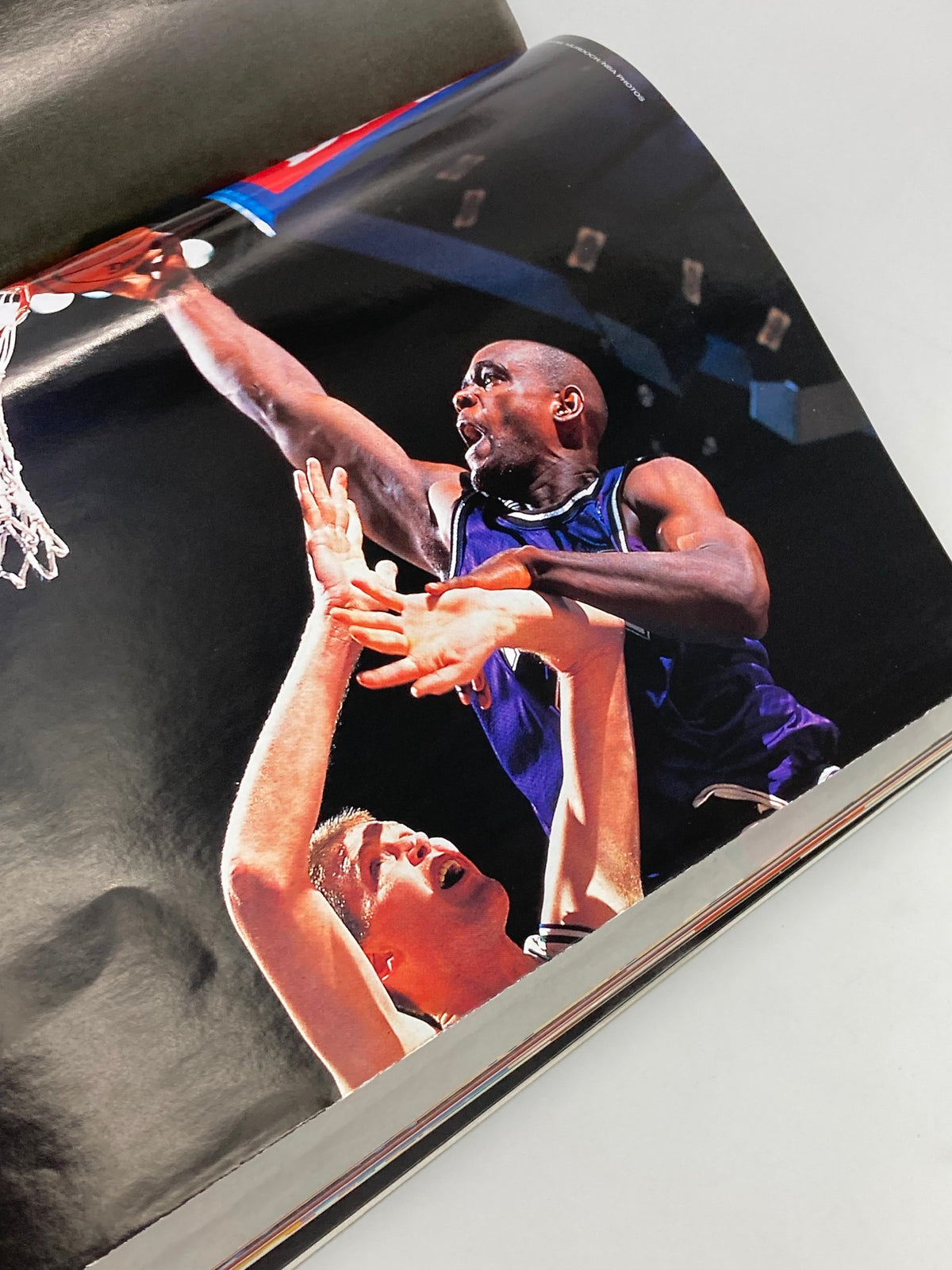 Dynamic action shot from Slam Magazine October 1999 showing a basketball player making a dunk, capturing the intensity of the NBA during that era.